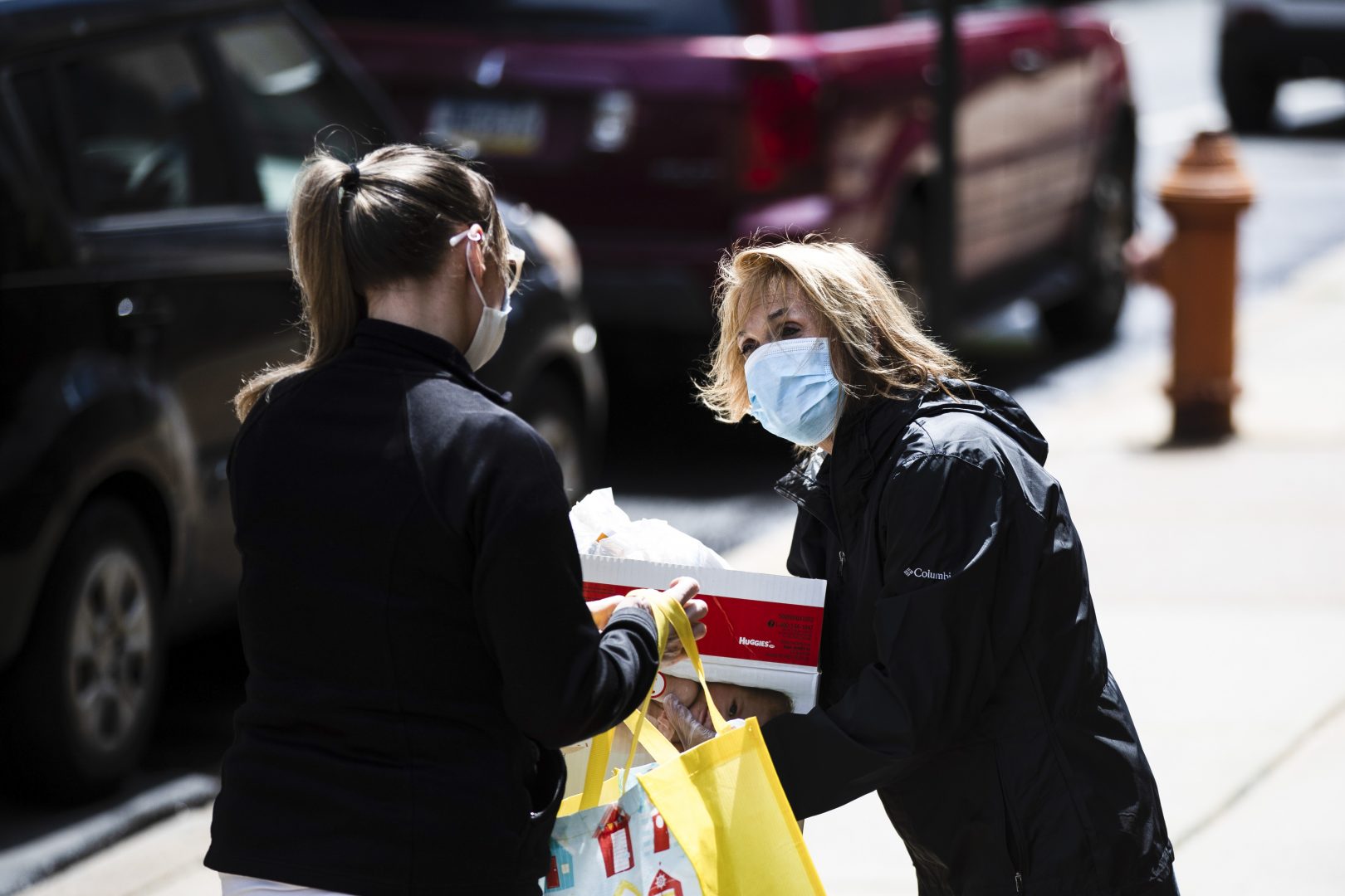 Nita Weightman, right, brings diapers and food for curbside pickup to a family in need in Philadelphia, Tuesday, April 21, 2020. .
