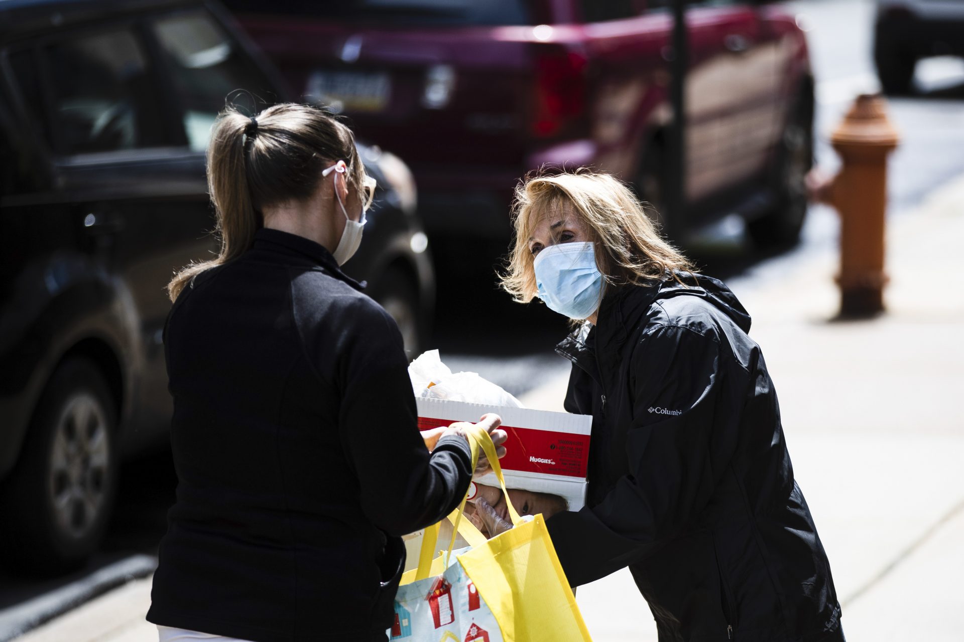 Nita Weightman, right, brings diapers and food for curbside pickup to a family in need in Philadelphia, Tuesday, April 21, 2020. The Nutritional Development Services of the Archdiocese of Philadelphia partnered with The City of Philadelphia to distribute the diapers which were provided by the Greater Philadelphia Diaper Bank and Mitzvah Circle.