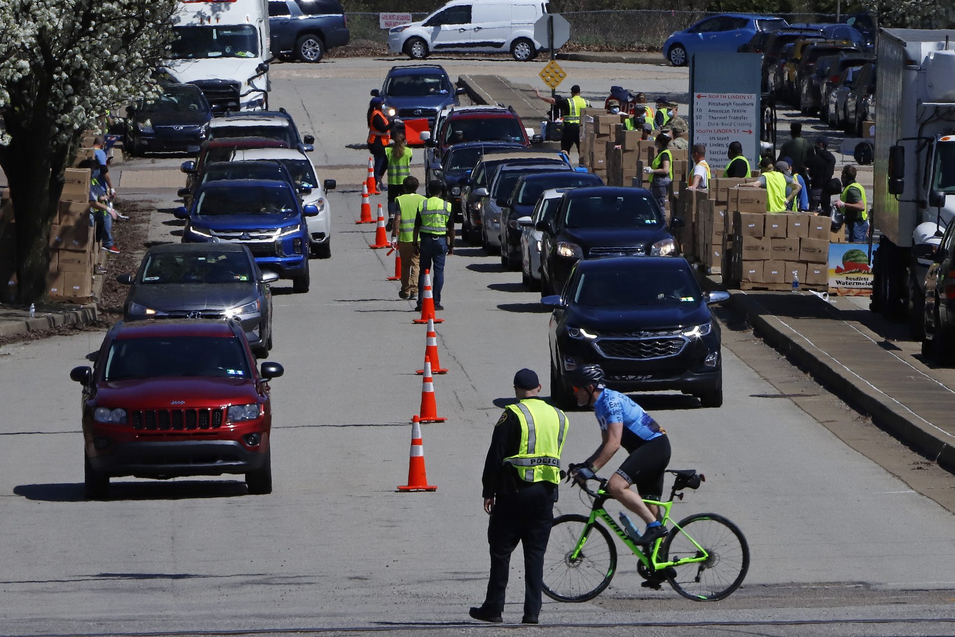 A double line of cars, stretching over a mile at times, are queued waiting as volunteers load food into vehicles outside the Greater Pittsburgh Community Food Bank in Duquesne, Pa., Monday, April 6, 2020. The COVID-19 pandemic has triggered a 543% increase in people coming to the food bank directly for food, according to the food bank's website.