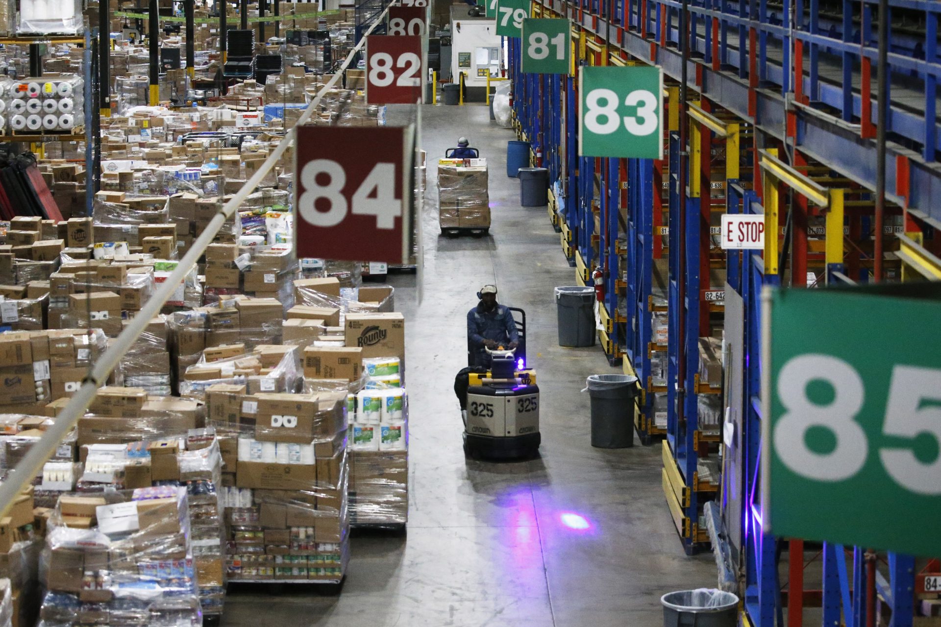 Employees work at the Associated Foods Stores distribution warehouse, Friday, March 20, 2020, in Farr West, Utah. Associated Foods Stores supplies grocery retailers in Oregon, Idaho, Montana, Wyoming, Utah, Colorado and Nevada.