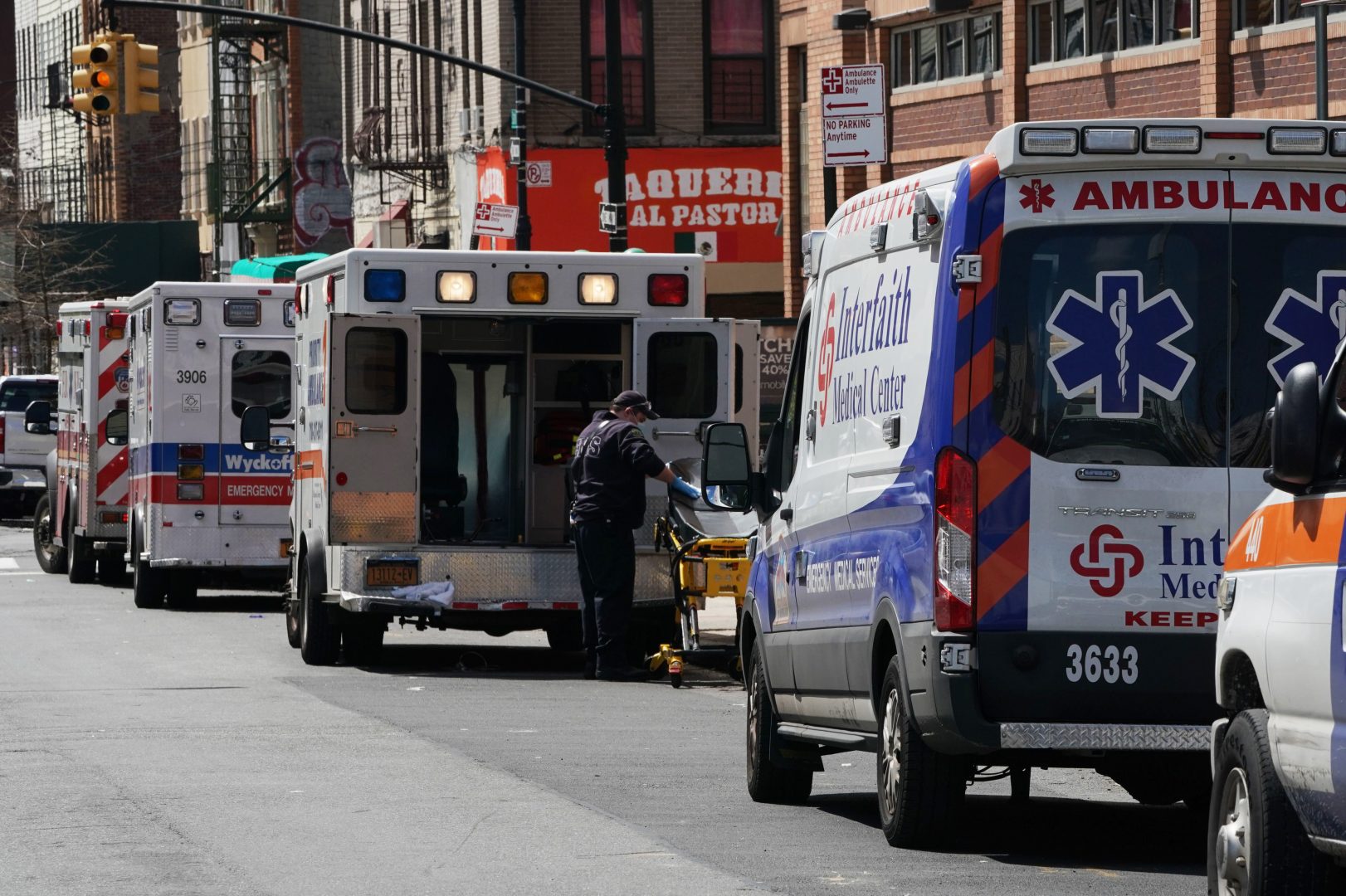 Ambulances are parked outside of Wyckoff Hospital in the Brooklyn, N.Y., on April 4. A study published by the CDC finds that people in the United States under the age of 18 are far less likely to fall ill with COVID-19 or require intensive care, compared with older Americans.