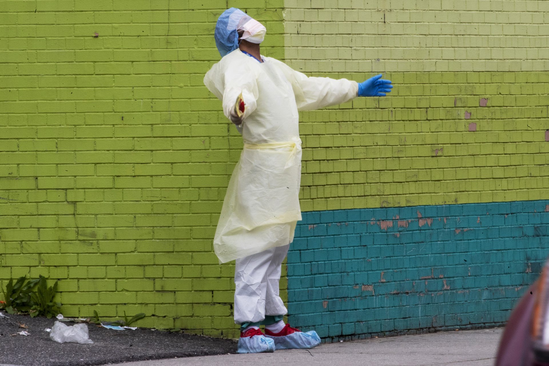 A medic of the Elmhurst Hospital Center medical team reacts after stepping outside of the emergency room, Saturday, April 4, 2020, in the Queens borough of New York. The new coronavirus causes mild or moderate symptoms for most people, but for some, especially older adults and people with existing health problems, it can cause more severe illness or death.