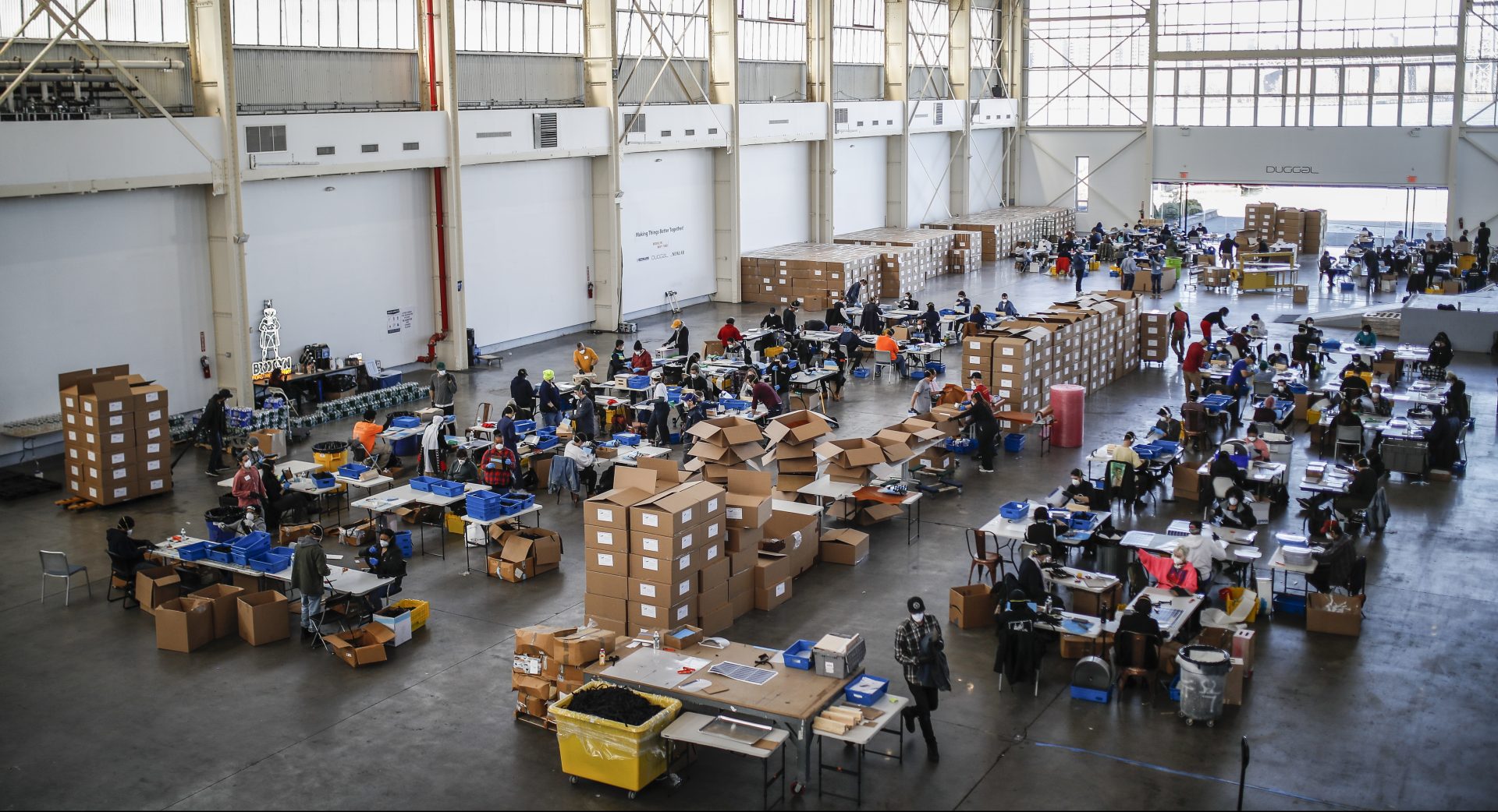 Workers wearing personal protective equipment build splash guards during a mass manufacturing operation to supply New York City government with protection to distribute against COVID-19 transmission, Friday, March 27, 2020, at the Brooklyn Navy Yard in New York. The new coronavirus causes mild or moderate symptoms for most people, but for some, especially older adults and people with existing health problems, it can cause more severe illness or death.