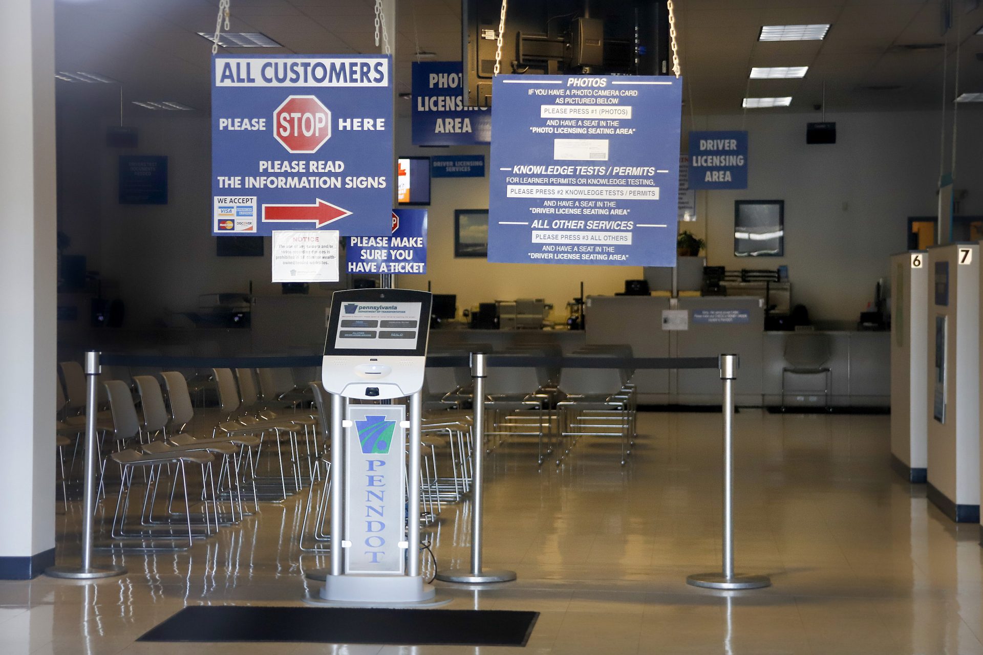 The seats and aisles are empty as seen through the window of the closed Penndot Drivers License Center in Butler, Pa., Friday, April 3, 2020. Pennsylvania will stop paying about 9,000 state workers whose offices have been closed as a result of the coronavirus pandemic, officials said Friday. The pay freeze affects about 12% of the state workforce, though individual agencies were hit much harder, with the state departments of Transportation and Revenue halting pay to more than half their employees.