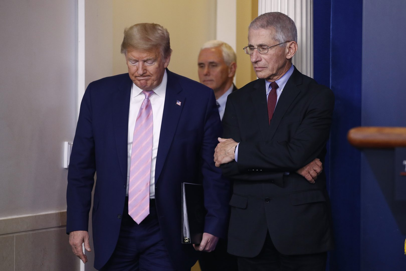 President Donald Trump walks past Dr. Anthony Fauci, right, director of the National Institute of Allergy and Infectious Diseases, as he and Vice President Mike Pence arrive to speak at a coronavirus task force briefing at the White House, Saturday, April 4, 2020, in Washington. 
