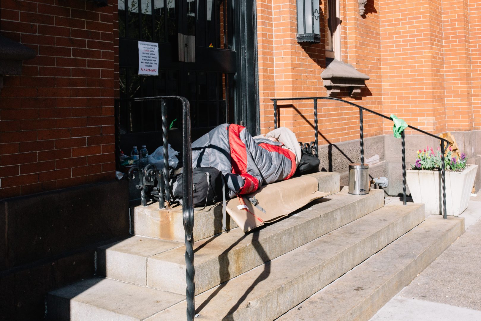A homeless person lies in a sleeping bag outside the United Way in Harrisburg on April 10, 2020.