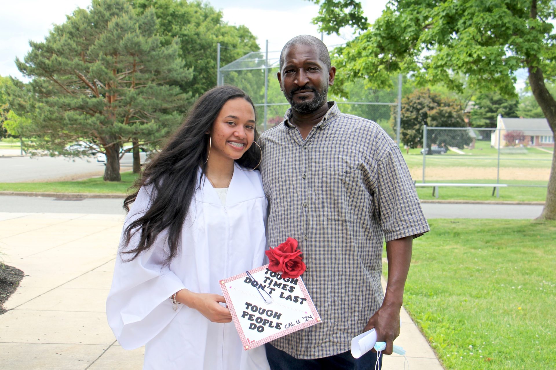 Pottstown High School senior Melissa Coleman poses with her father, James Coleman, after a socially distant graduation ceremony.