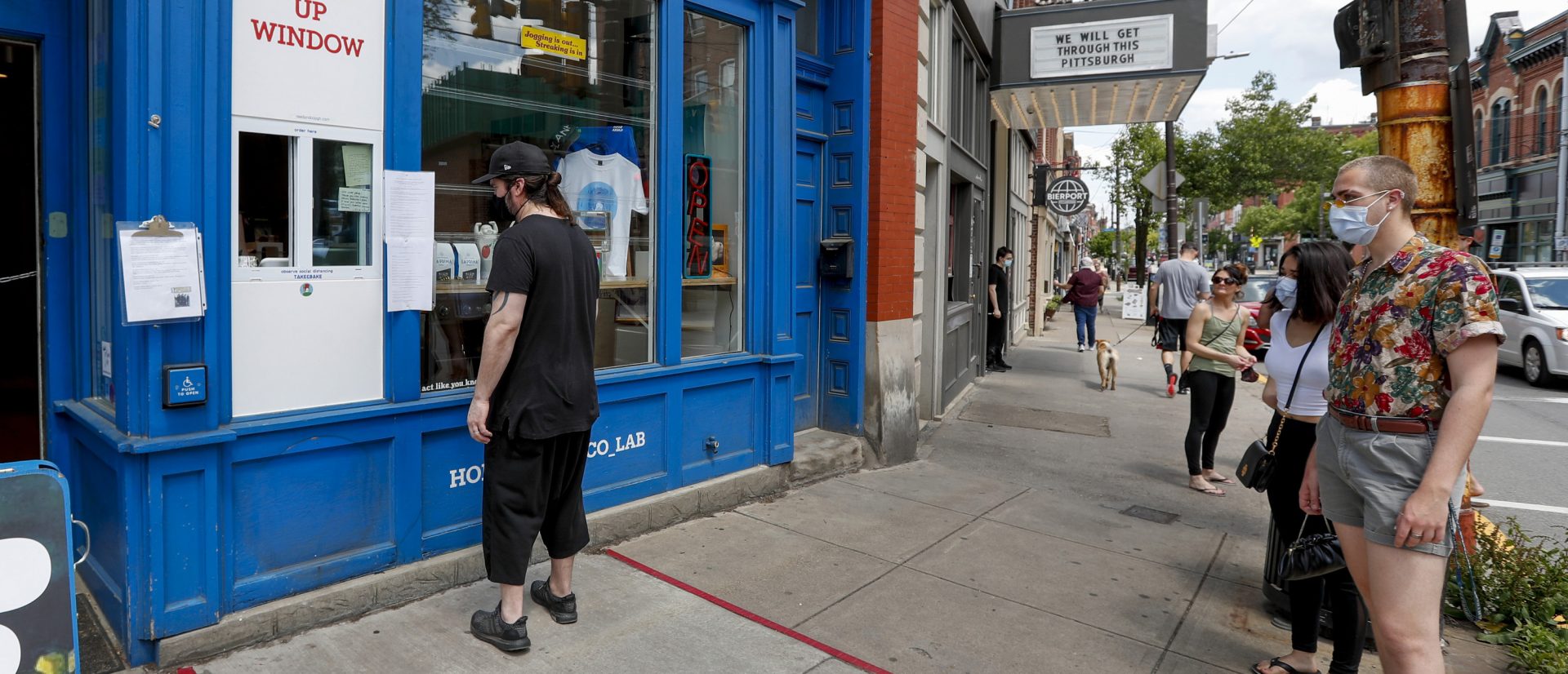 People wait for a take-out order at a restaurant along Butler Street in Pittsburgh's Lawrenceville neighborhood as counties in southwestern Pennsylvania join northwestern and the north central regions with more relaxed COVID-19 prevention restrictions, Friday, May 15, 2020, in Pittsburgh.
