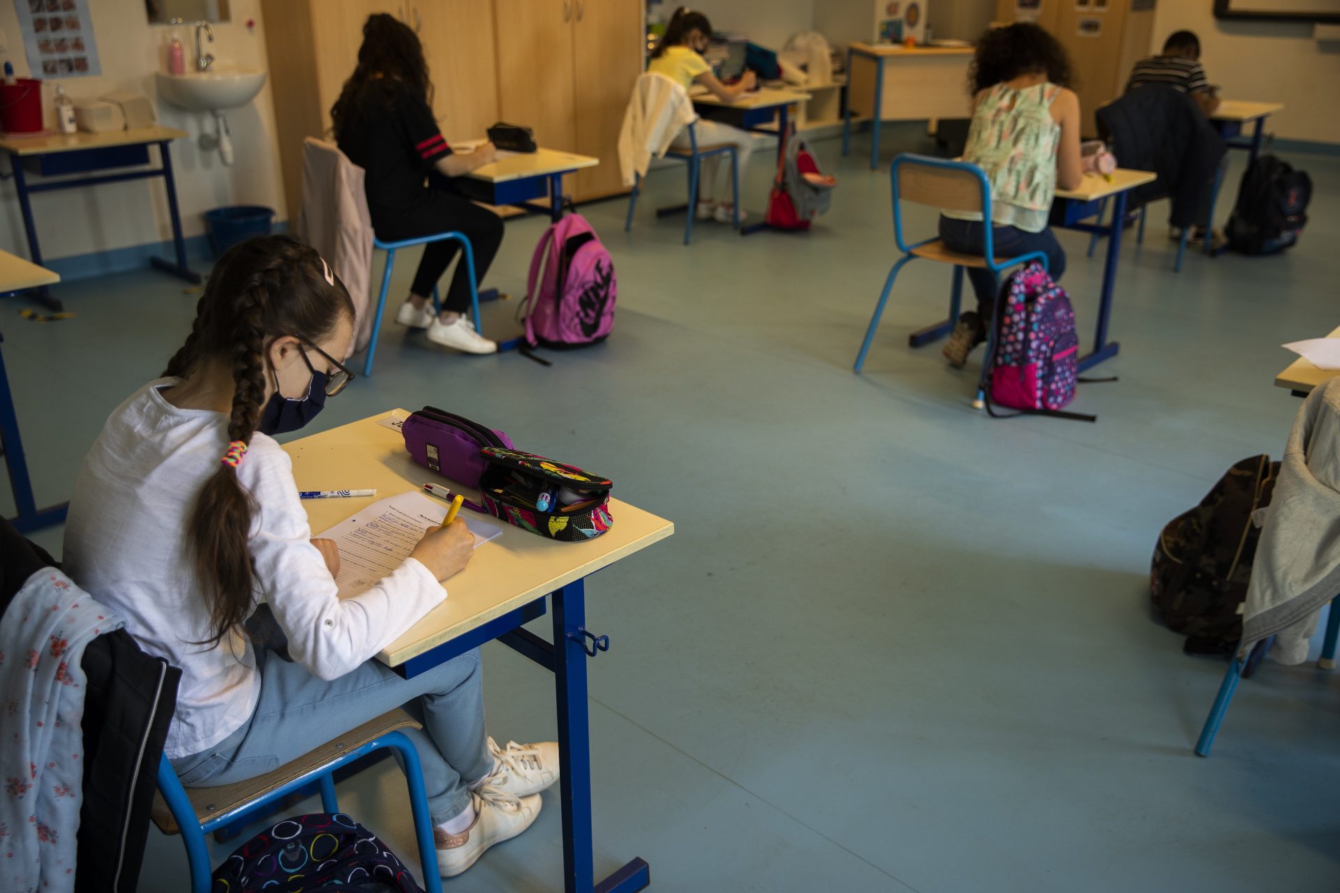 Students, wearing face masks and paying attention to social distancing, study at Les Magnolias primary school during the partial lifting of coronavirus, COVID-19, lockdown regulations in Brussels, Monday, May 18, 2020. Belgium is taking the next step in its relaxation of the coronavirus lockdown on Monday, with more students going to school, markets and museums reopening and the snip of a barber's scissors filling the air again.