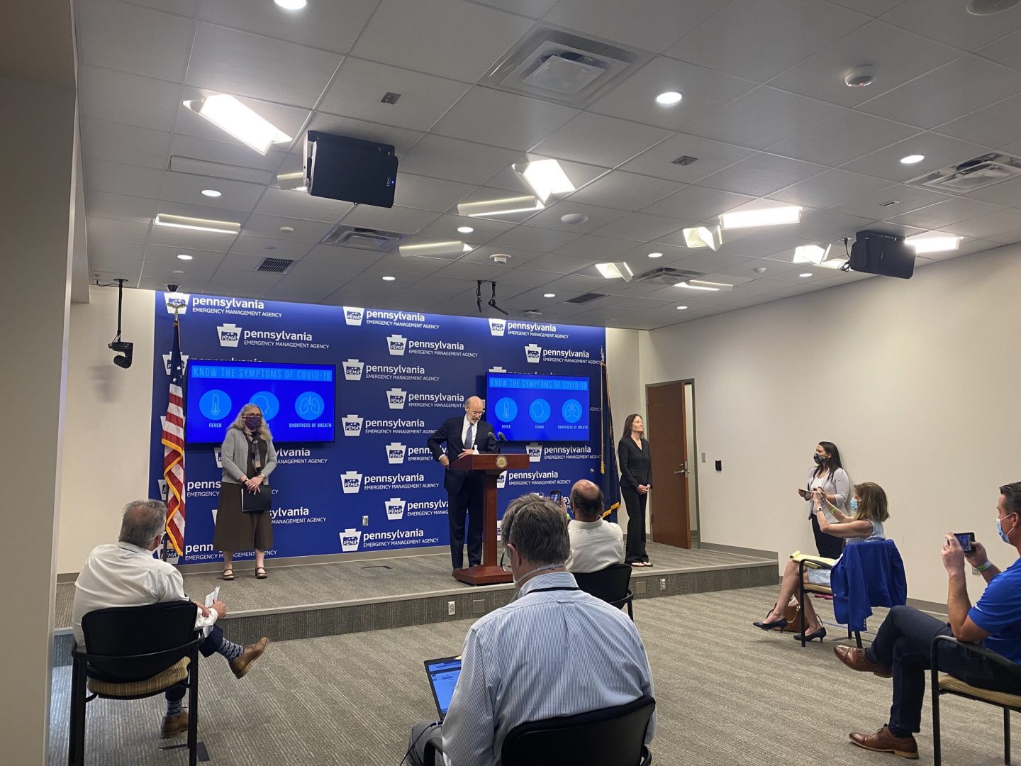 Gov. Tom Wolf stands at the podium at the start of his first in-person press conference since March. Wolf and Health Secretary Rachel Levine spoke to the press from the Pennsylvania Emergency Managment Agency in Harrisburg.