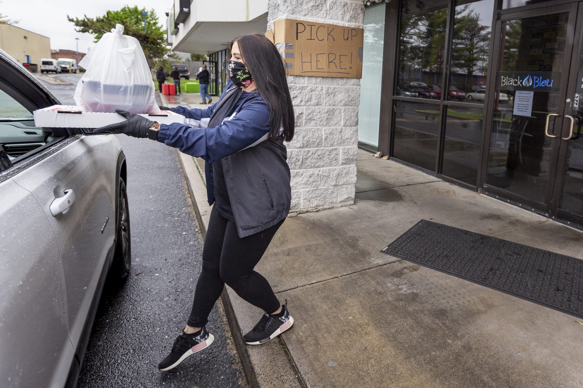 Jordan Copenhaver delivers take out to a car outside of Black 'n Bleu in Mechanicsburg on May 6, 2020. The restaurant has adapted to serving take out only during the COVID-19 pandemic.