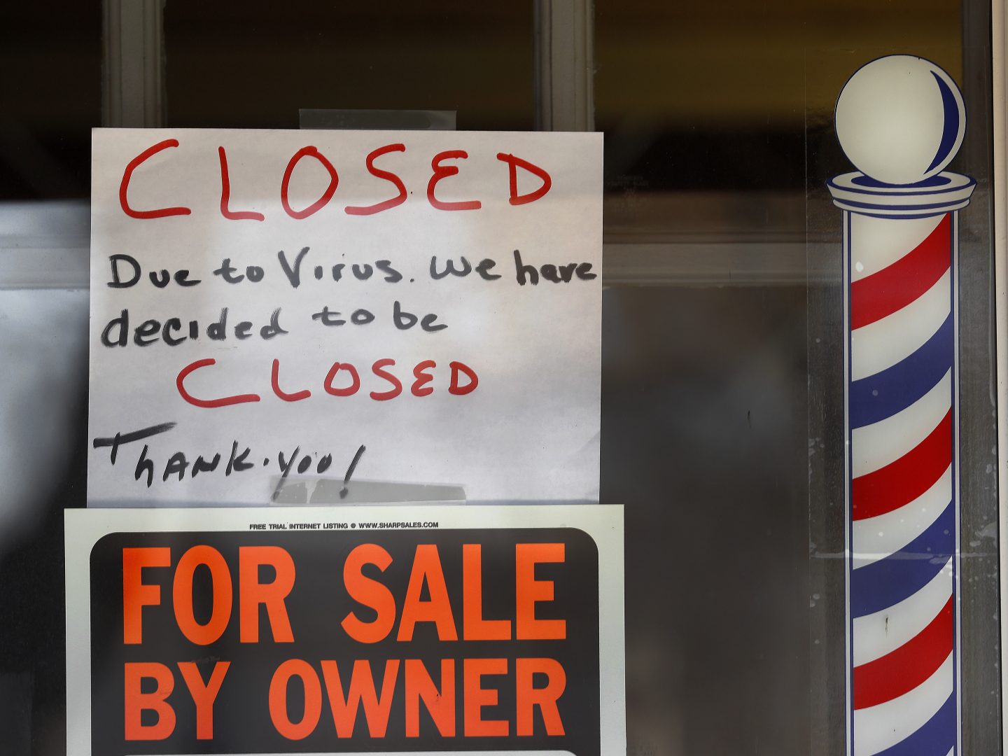 Signs are displayed in the window of a store in Grosse Pointe Woods, Mich. The Paycheck Protection Program, aimed at helping small businesses survive the coronavirus crisis, has been beset by problems.