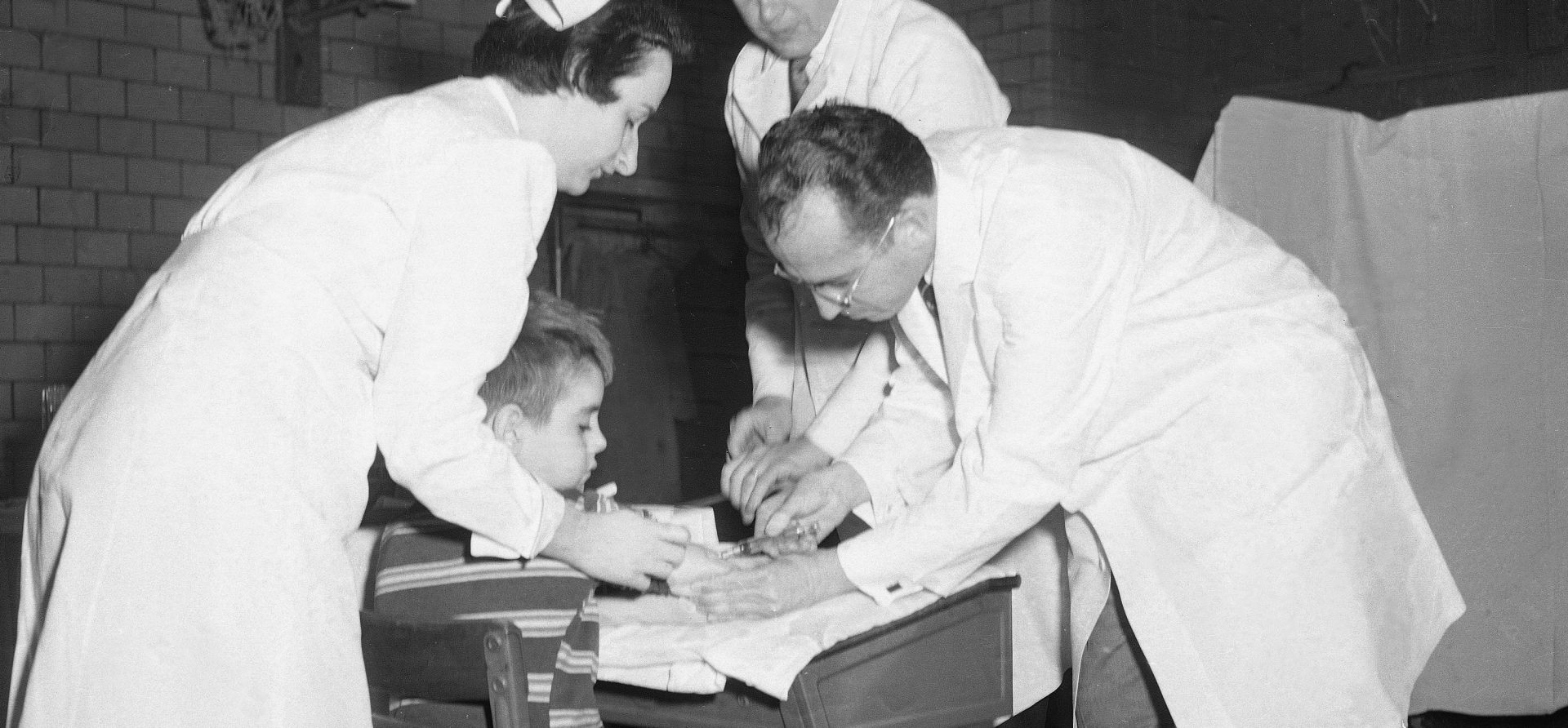 Dr. Jonas Salk, the scientist who created the polio vaccine, administers an injection to an unidentified boy at Arsenal Elementary School in Pittsburgh, Pa., in 1954.
