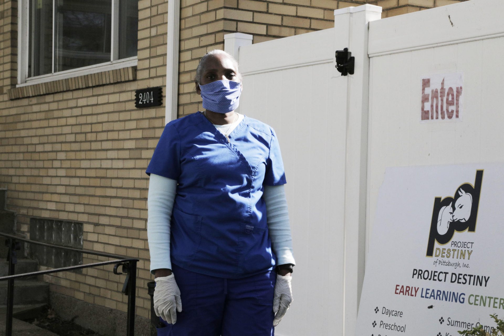 Gwen Marcus stands for a portrait outside of the north side child care center she directs. Marcus and her staff now wear scrubs, masks and gloves daily.