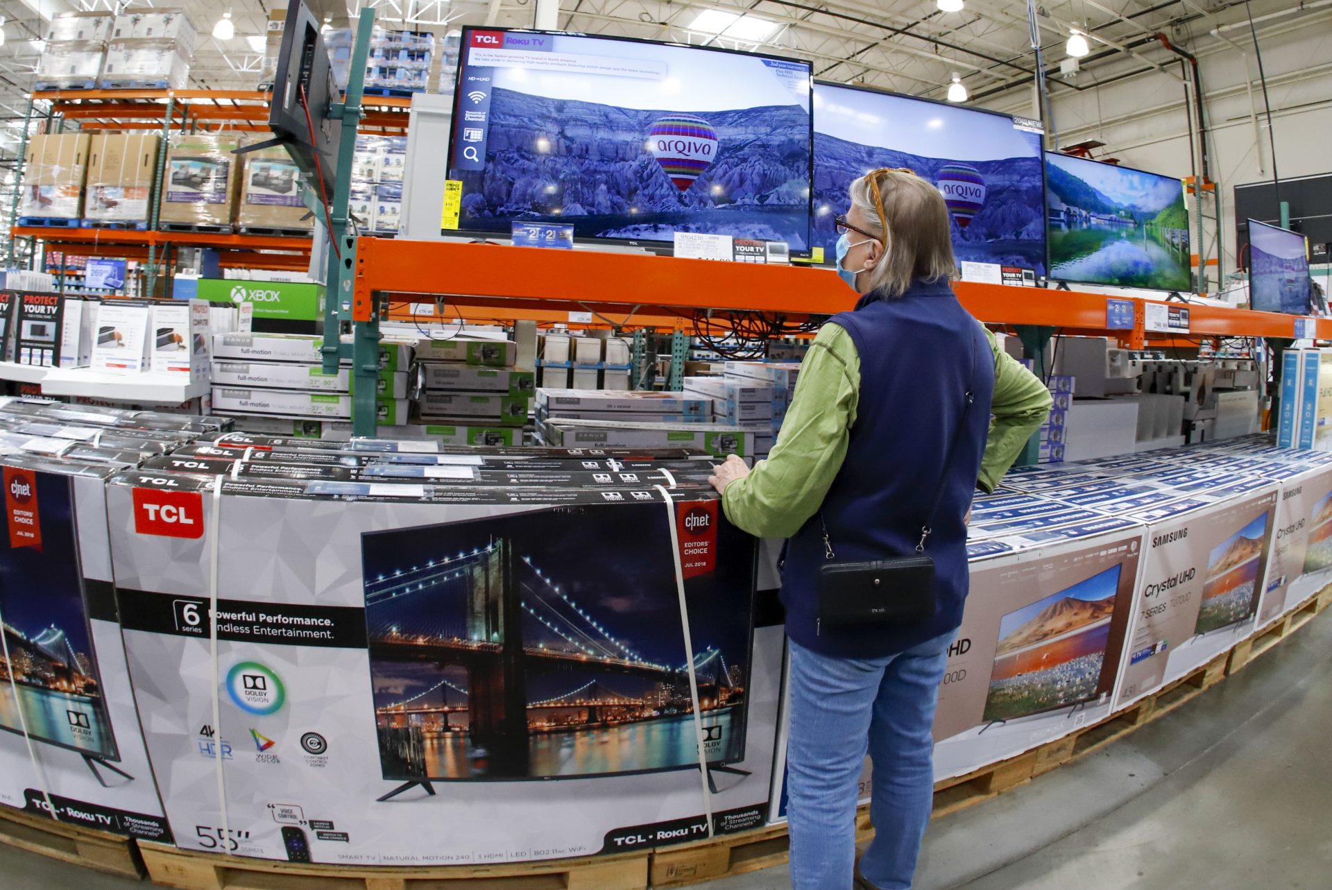 A shopper looks at a display of televisions at a Costco Warehouse in Robinson Township, Pa., on Thursday, May 14, 2020.