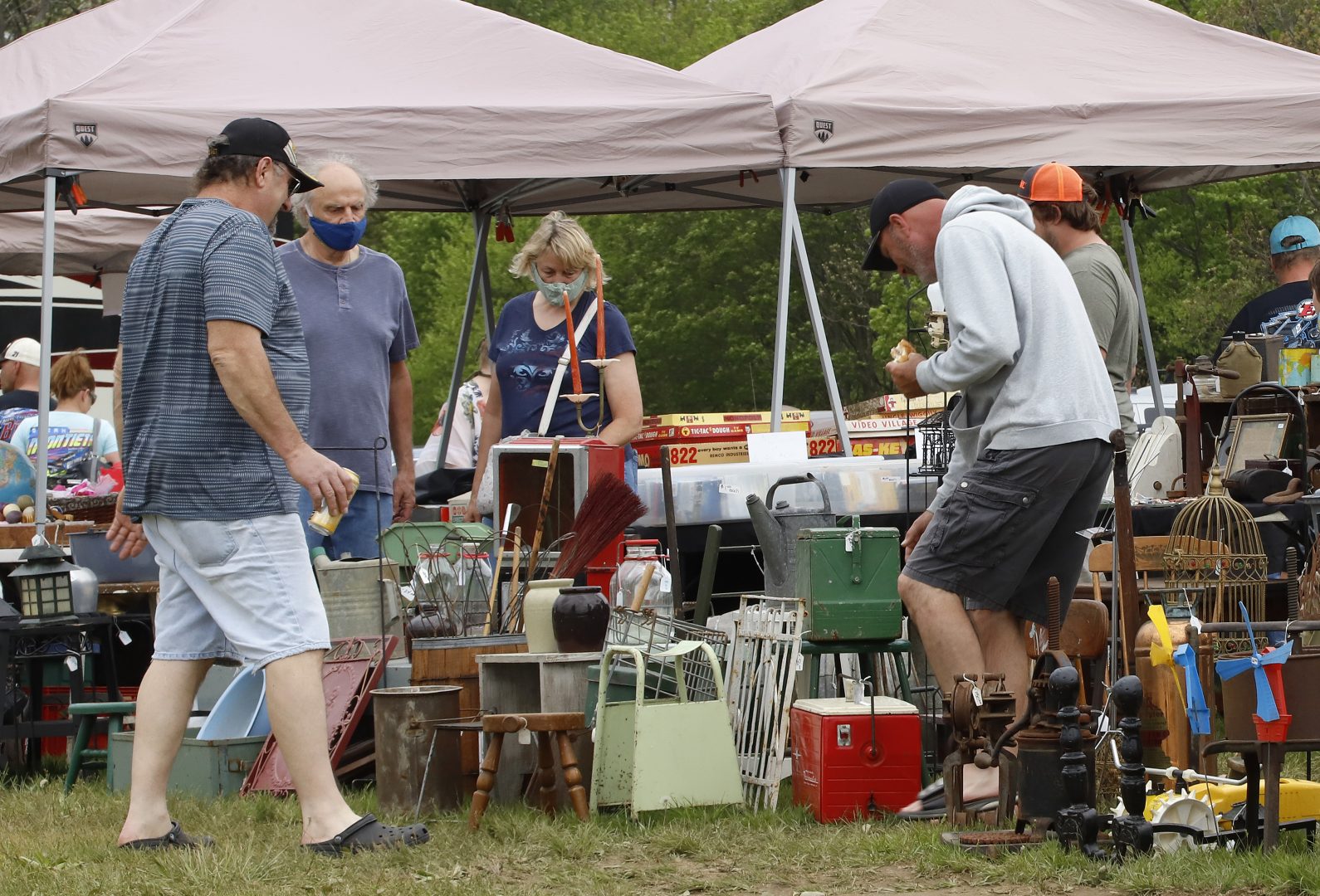 People gather around a vendor's tables at a flea market in Farmington, Pa., on Sunday, May 24, 2020. 