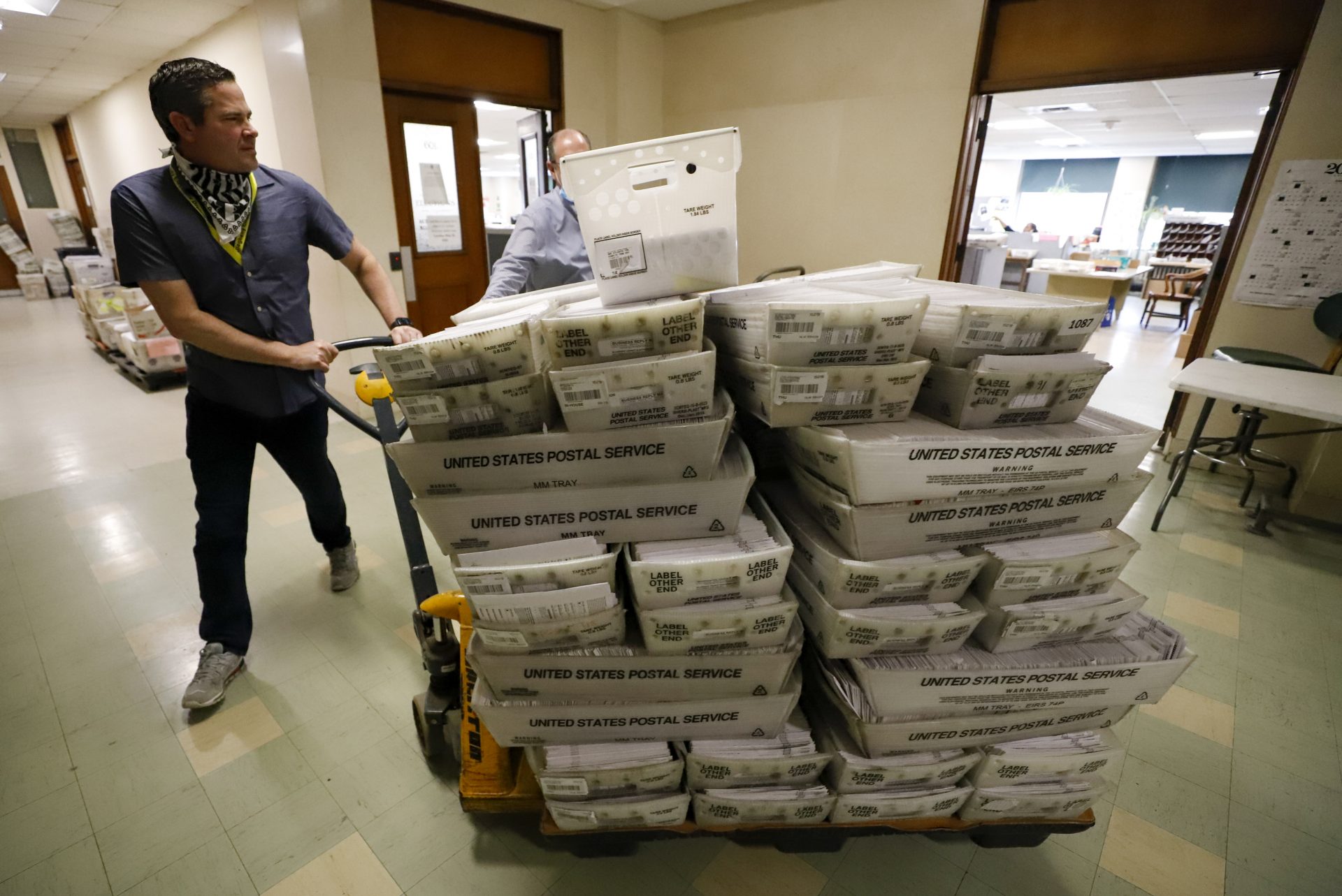 Chet Harhut, deputy manager, of the Allegheny County Division of Elections, wheels a dolly loaded with mail-in ballots, at the division of elections offices in downtown Pittsburgh Wednesday, May 27, 2020. The once-delayed June 2, Pennsylvania primary will feature legislative and congressional races, a first run for some new paper-record voting systems and the inaugural use of newly legalized mail-in ballots.