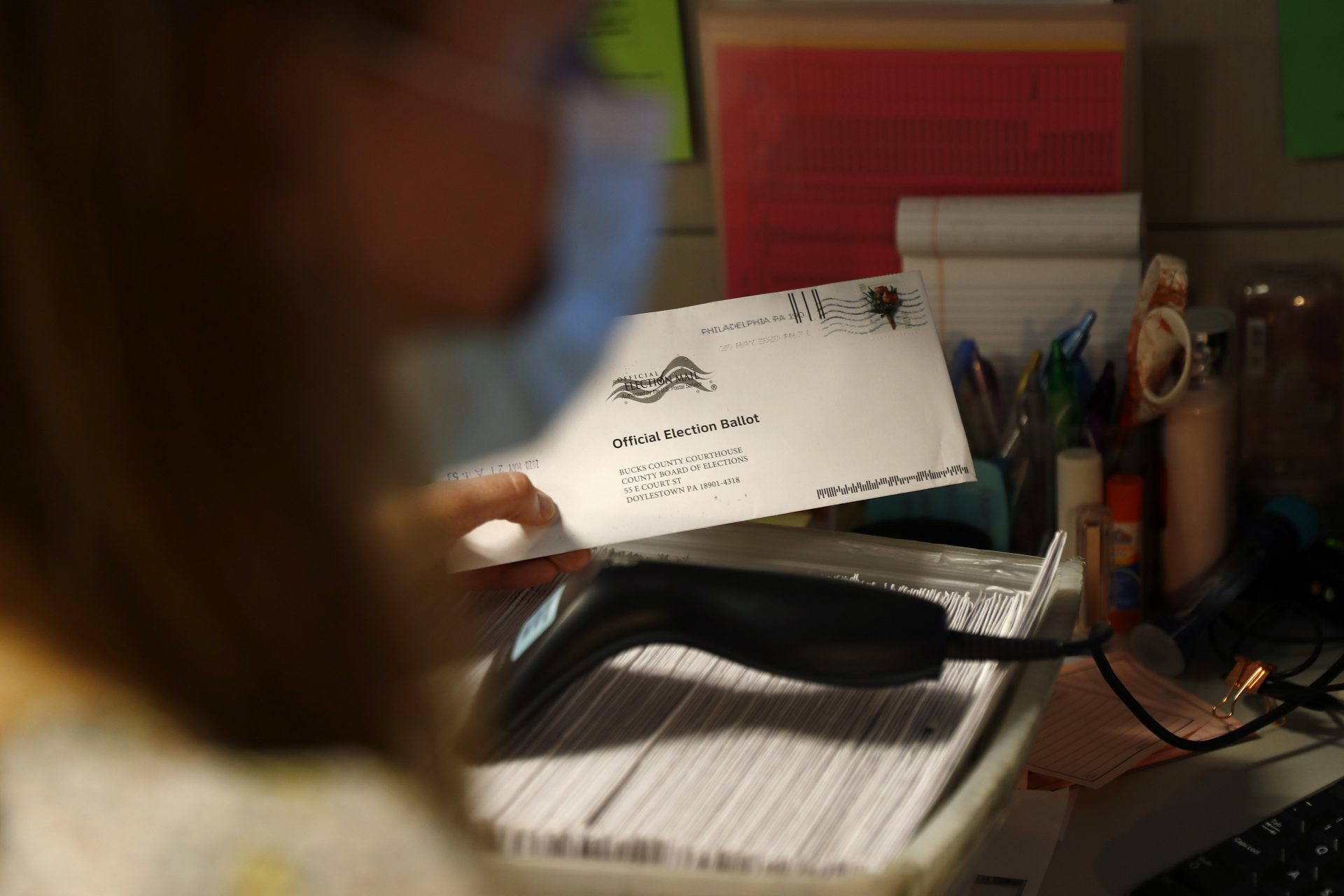 Election coordinator Charlene Maloney processes a mail-in ballot at the Bucks County Board of Elections office prior to the primary election, Wednesday, May 27, 2020 in Doylestown, Pa.