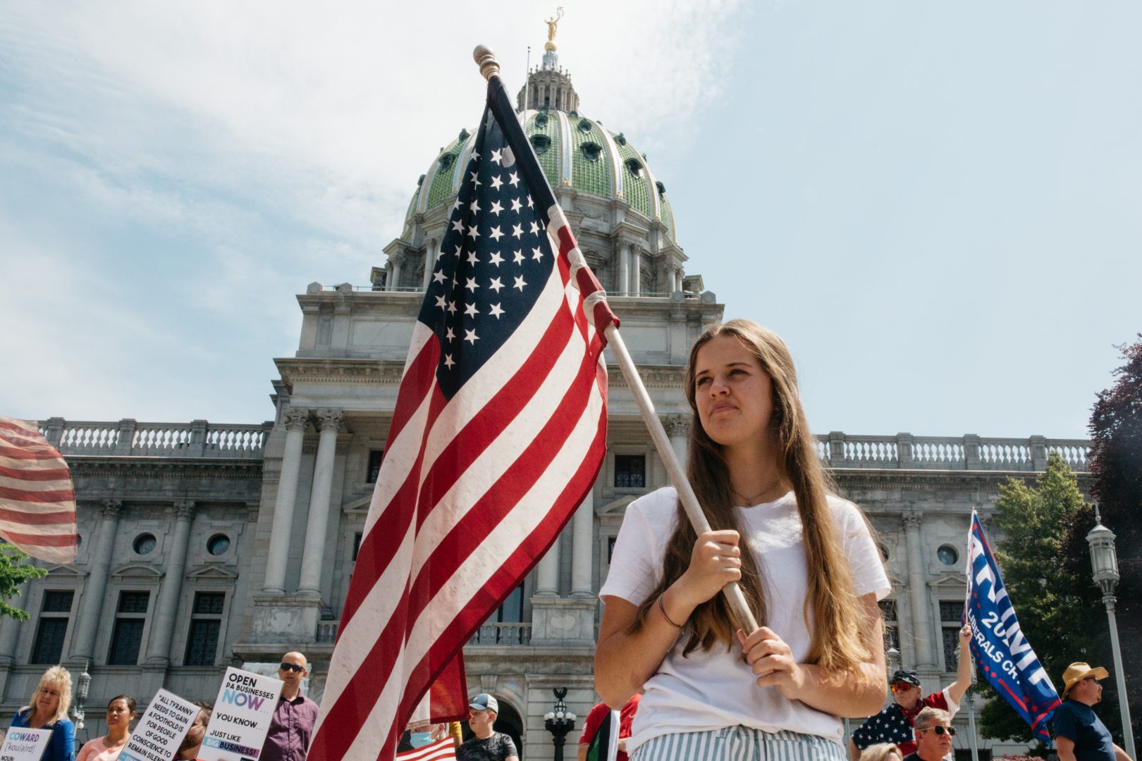 FILE PHOTO: A protester holds an American flag during a May 15, 2020, rally outside the state capitol in Harrisburg, Pa. About 1,000 people showed up to protest Gov. Wolf's coronavirus shutdown order.