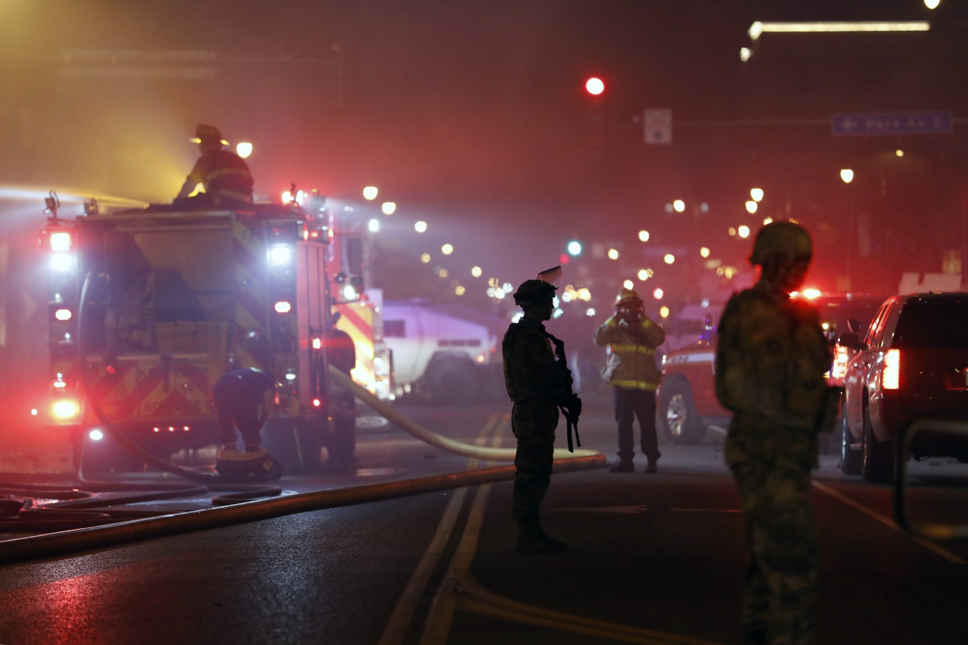 The National Guard standby as firefighters extinguish a blaze at a gas station Friday, May 29, 2020, in Minneapolis. Protests continued following the death of George Floyd, who died after being restrained by Minneapolis police officers on Memorial Day.