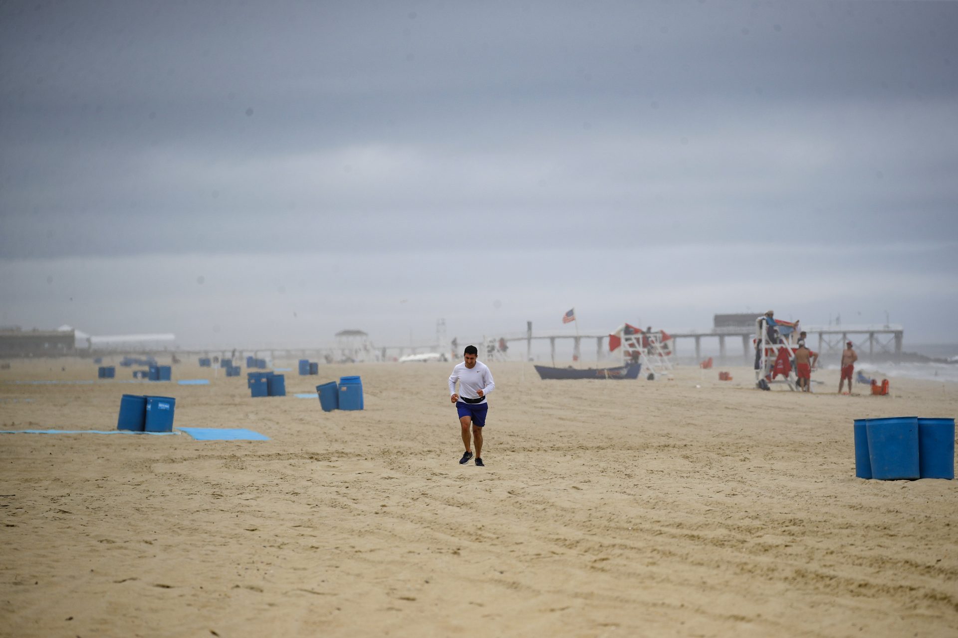 A runner passes along a mostly empty beach, Saturday, May 23, 2020, in Belmar, N.J.