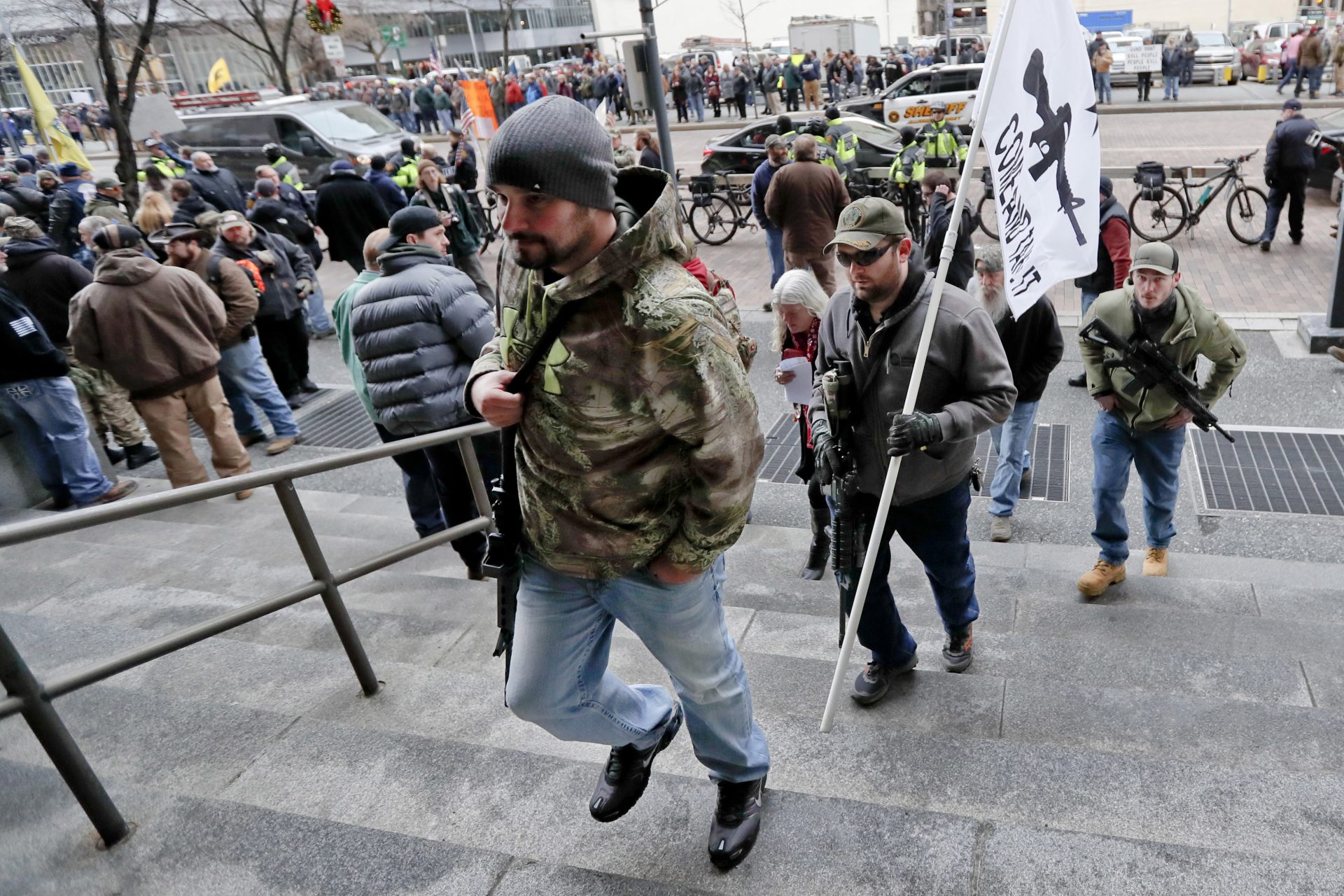 Protestors carrying rifles walk up the steps for a rally at the City County building on Monday, Jan. 7, 2019, in Pittsburgh. The protesters, many openly carrying guns, gathered in downtown Pittsburgh to rally against the city council's proposed restrictions and banning of semi-automatic rifles, certain ammunition and firearms accessories within city limits.