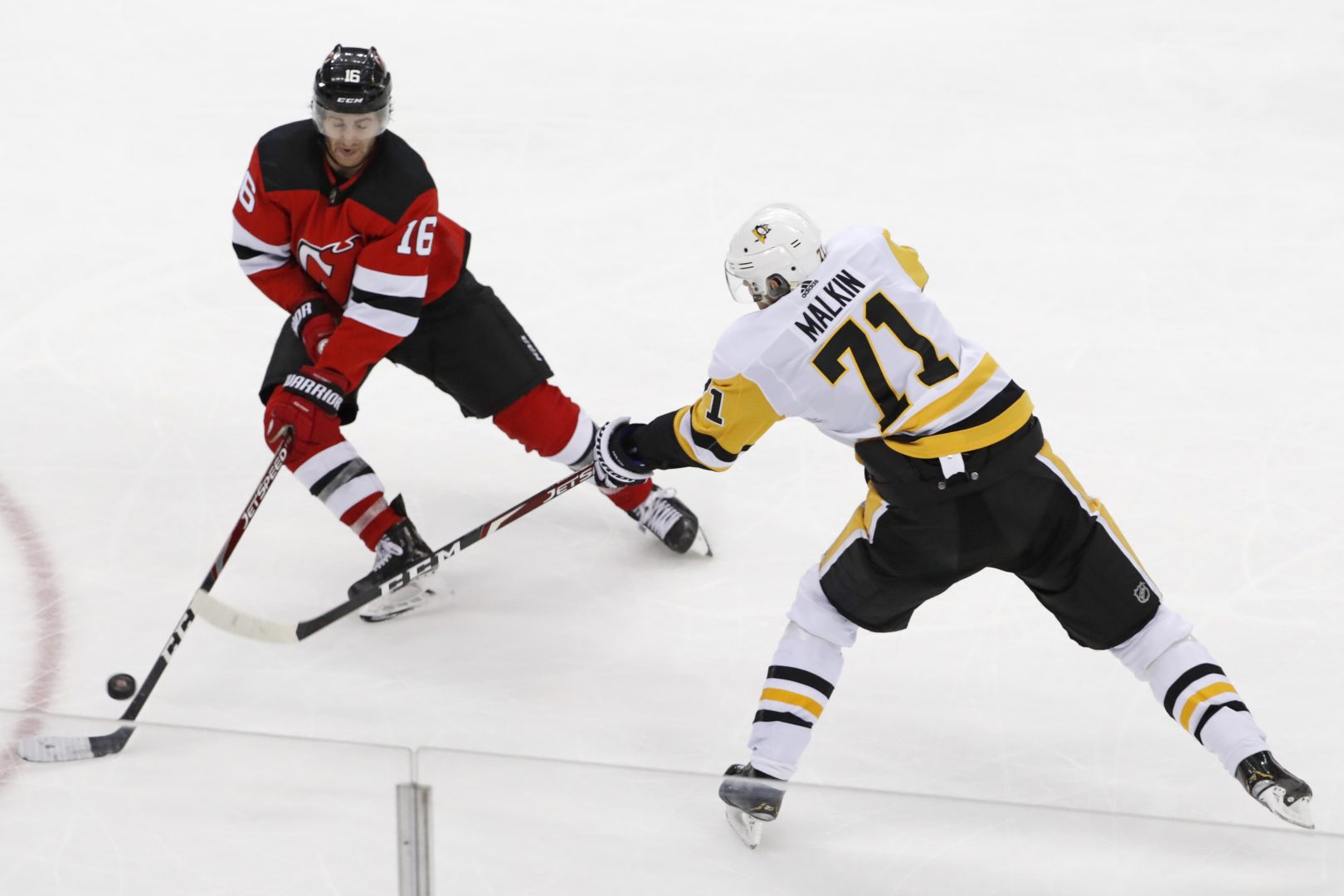 Pittsburgh Penguins center Evgeni Malkin (71) takes a shot with New Jersey Devils center Kevin Rooney (16) defending during the third period of an NHL hockey game Tuesday, March 10, 2020, in Newark, N.J. 