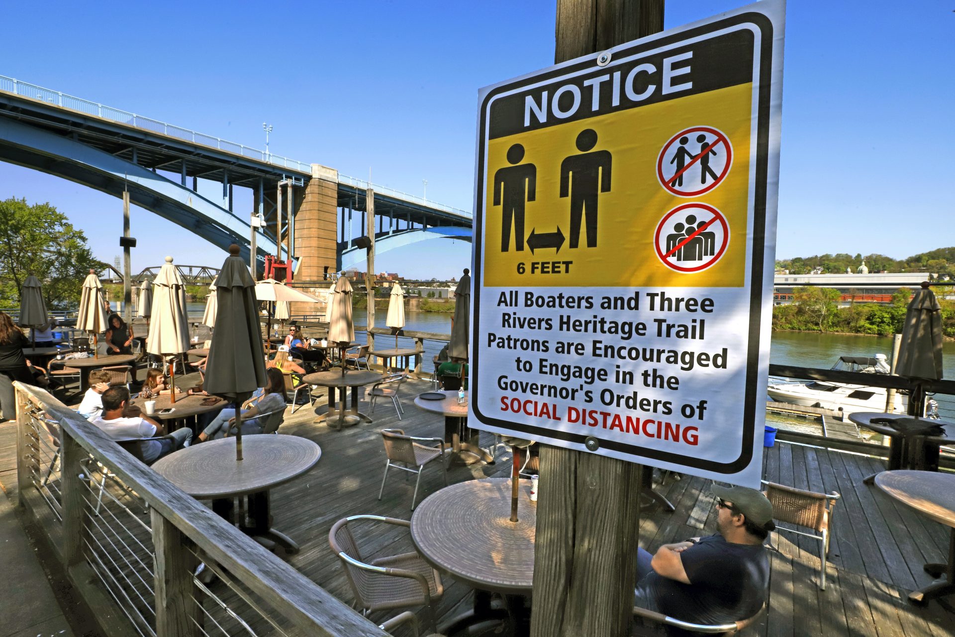 Patrons enjoy their takeout on the deck at Redfin Blues restaurant, overlooking the Allegheny River, on Wednesday, May 13, 2020 in Pittsburgh