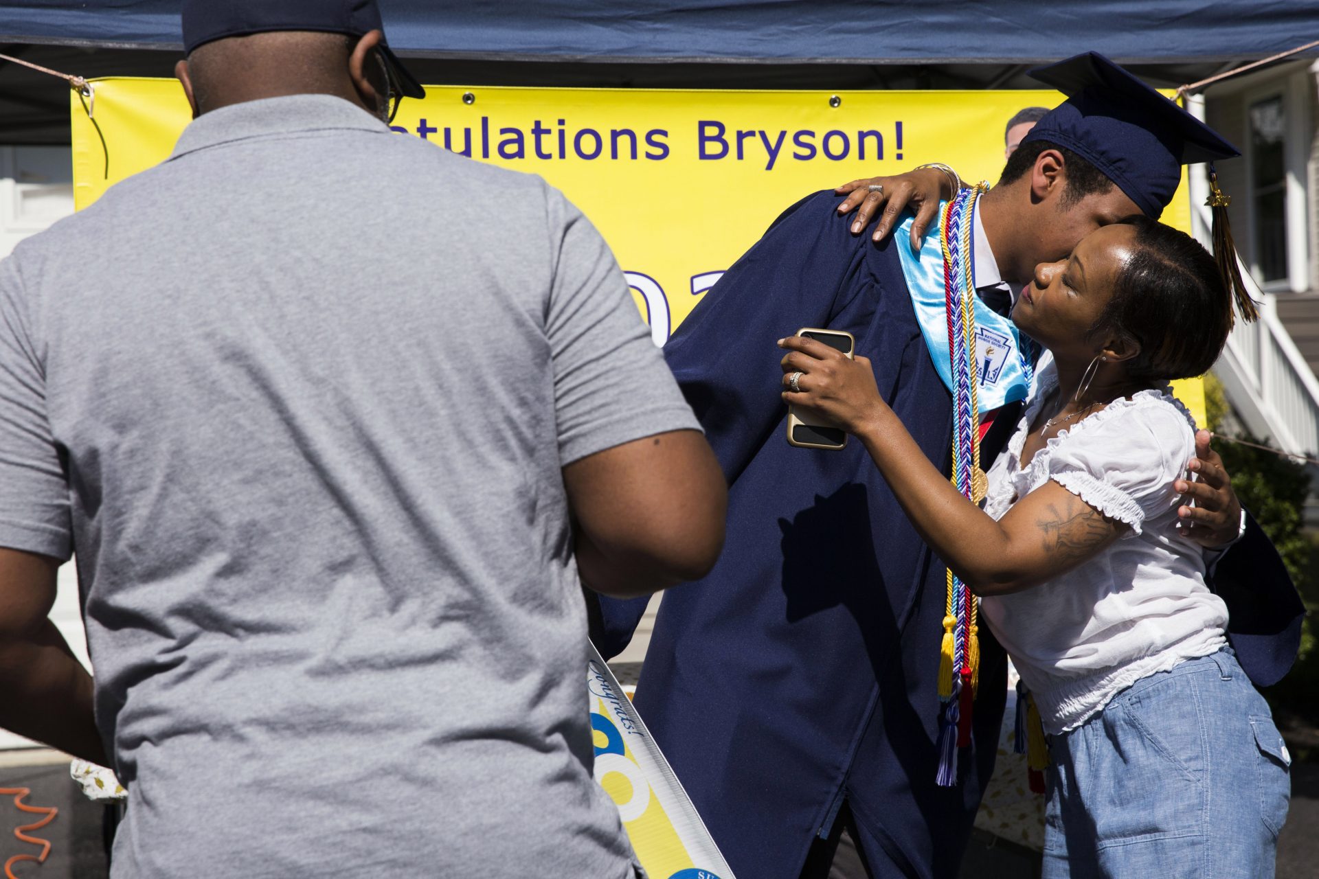 Bryson Eldridge (center) receives congratulations from his parents, Elaina and Greg, after receiving his high school diploma via a modified graduation ceremony on June 9, 2020.