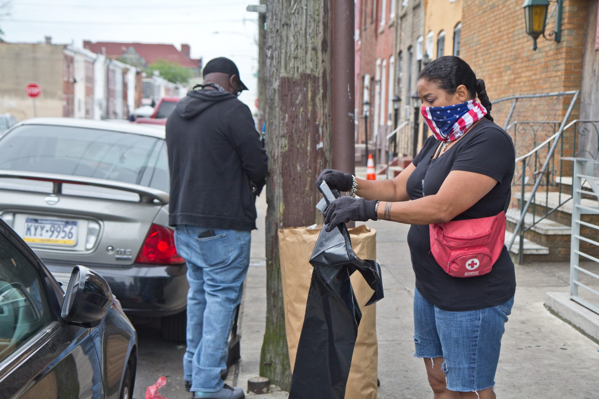 Kensington resident and community leader Rosalind Pichardo (right) was out Tuesday morning cleaning streets after a night of unrest.