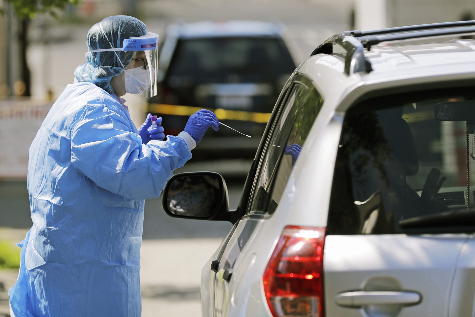 Tina Nguyen, a nurse at at the International Community Health Services clinic in Seattle's International District, takes a nose swab sample from a patient during drive-up testing for COVID-19, Friday, May 15, 2020.