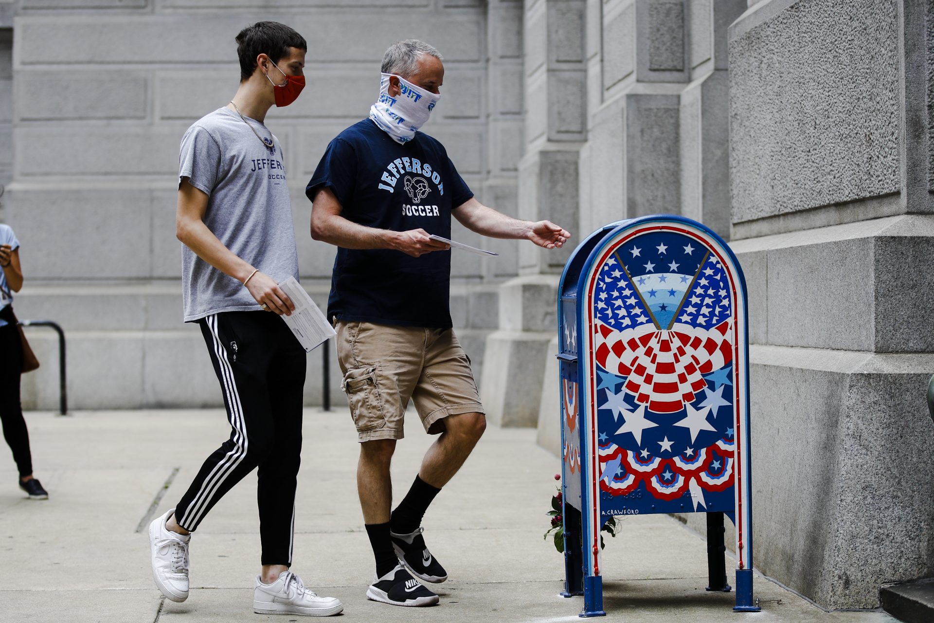Benjamin Graff, center, and his son Jacob Graff, 19, drop off their mail-in ballots for the Pennsylvania primary election, in Philadelphia, Tuesday, June 2, 2020. (AP Photo/Matt Rourke)