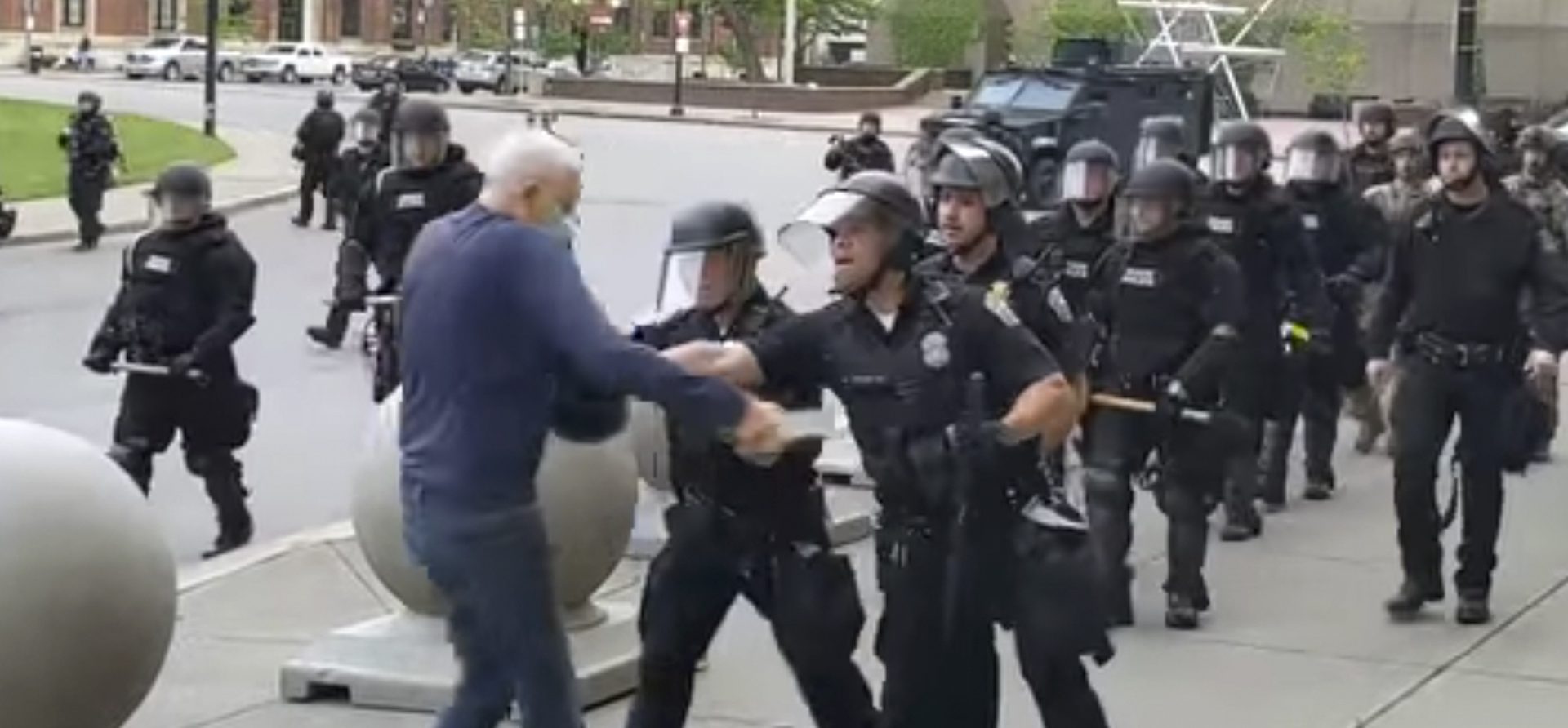 In this image from video provided by WBFO, a Buffalo police officer appears to shove a man who walked up to police Thursday, June 4, 2020, in Buffalo, N.Y. Video from WBFO shows the man appearing to hit his head on the pavement, with blood leaking out as officers walk past to clear Niagara Square. Buffalo police initially said in a statement that a person “was injured when he tripped & fell,” WIVB-TV reported, but Capt. Jeff Rinaldo later told the TV station that an internal affairs investigation was opened.