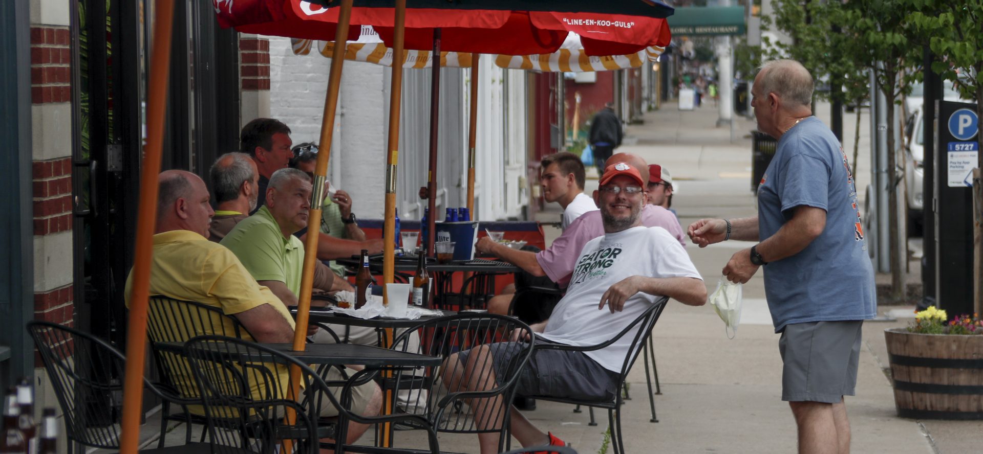 People take advantage of newly lowered COVID-19 protective restrictions in most of southwest Pennsylvania and have food and drinks on the sidewalk on the re-opening day for seated patrons at an eatery on Pittsburgh's Southside, Friday, June 5, 2020.
