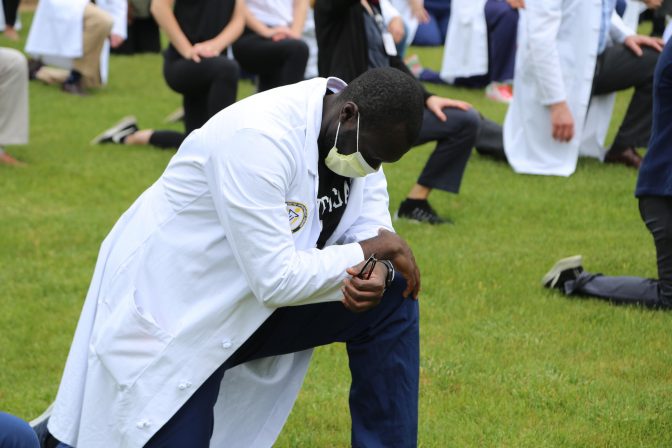 A medical professional takes a knee for 8 minutes and 46 seconds as part of demonstration organized by the group White Coats for Black Lives Matter outside of UPMC Presbyterian Hospital in Oakland on Friday, June 5, 2020.