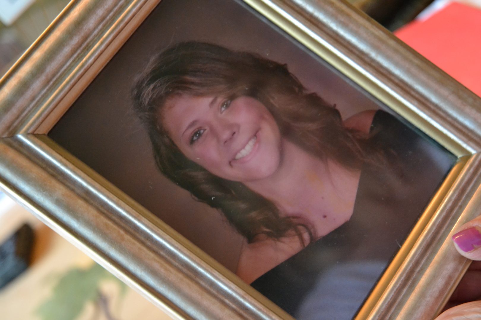 In this June 2019 photo, Martha Stringer holds a photo of her daughter, Kim. 