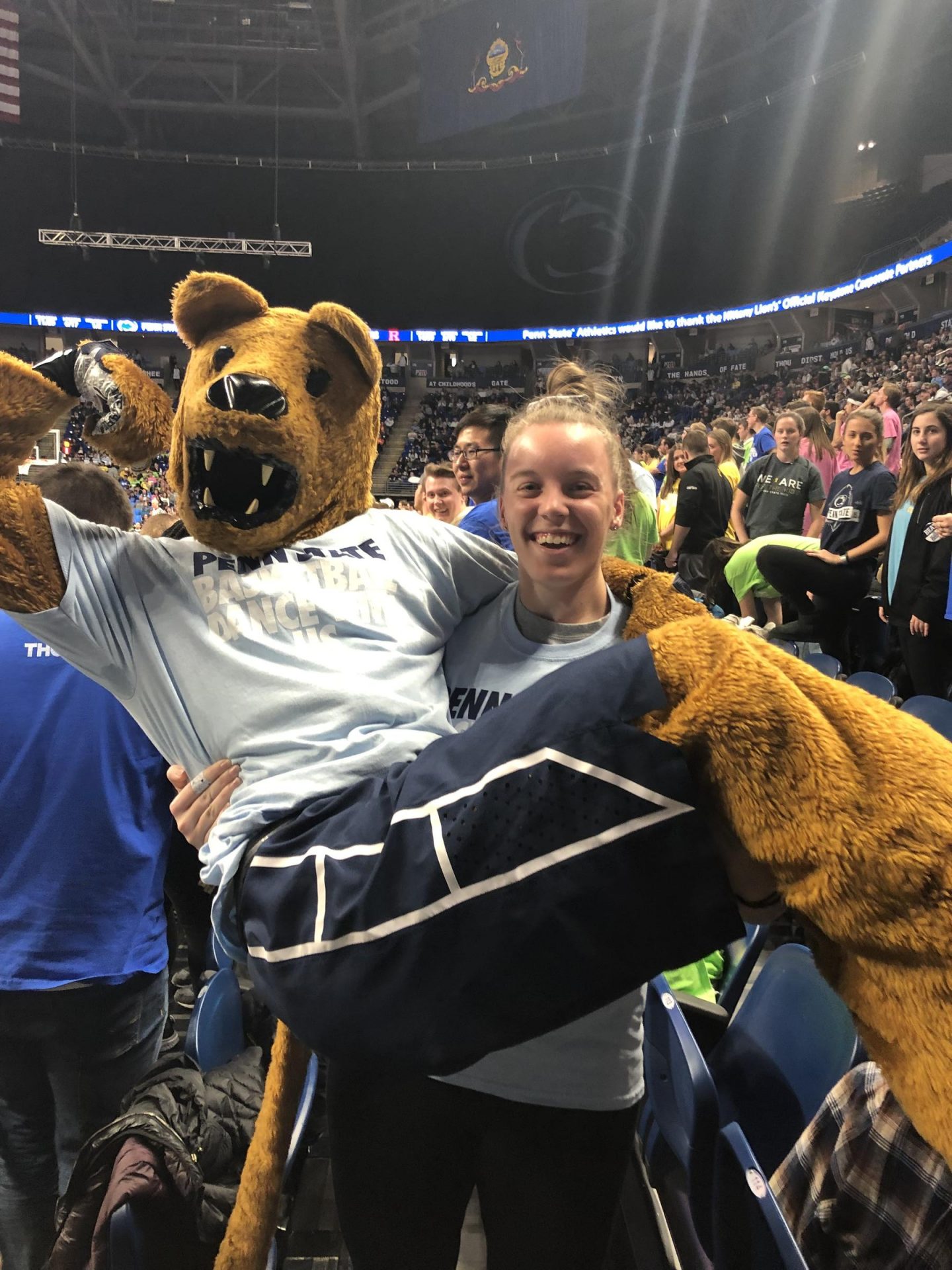 Lexy Leidlein carries the Nittany Lion mascot at a Penn State men's basketball game.