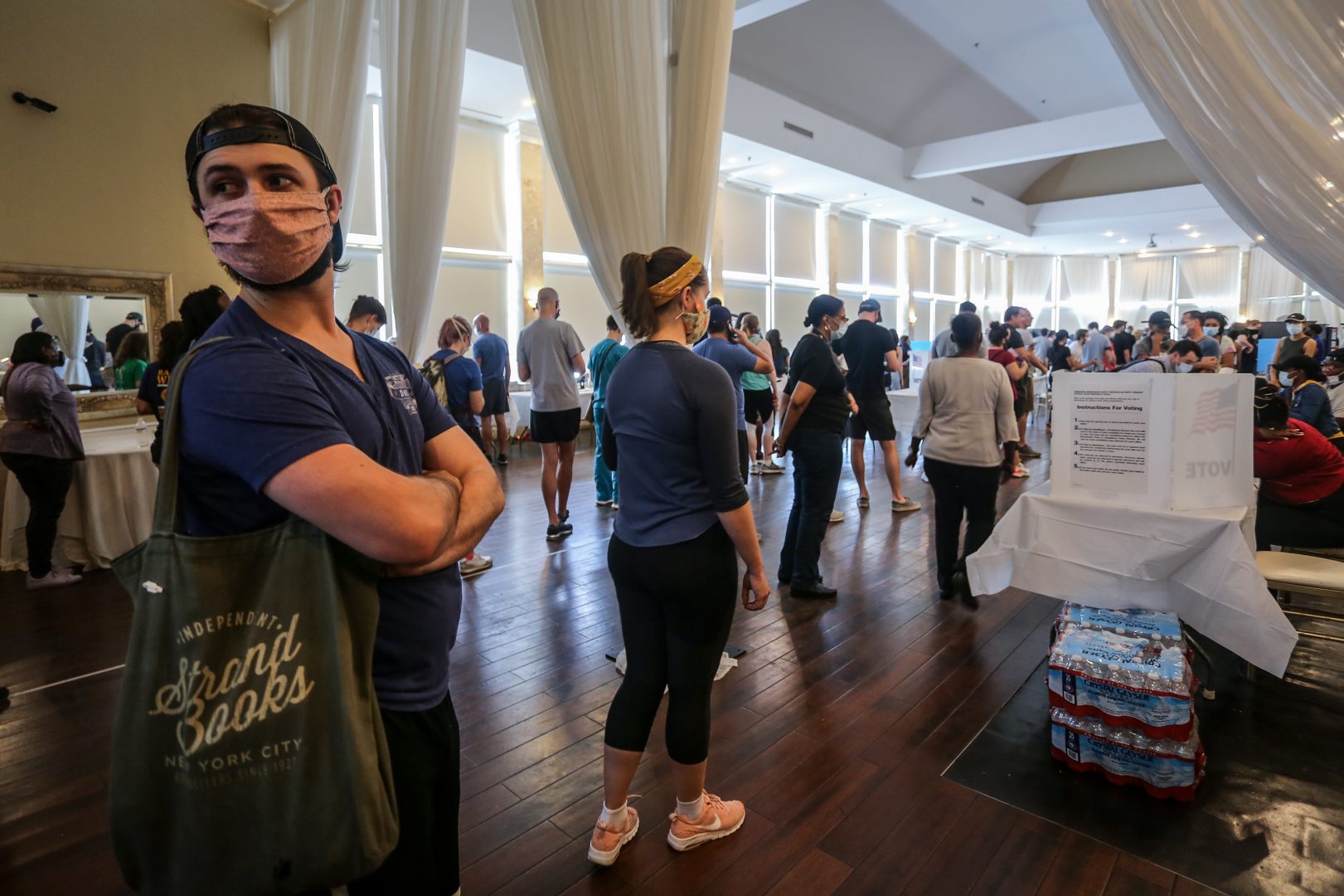 Voters wait in line to cast their ballots in the state's primary election at a polling place, Tuesday, June 9, 2020, in Atlanta.