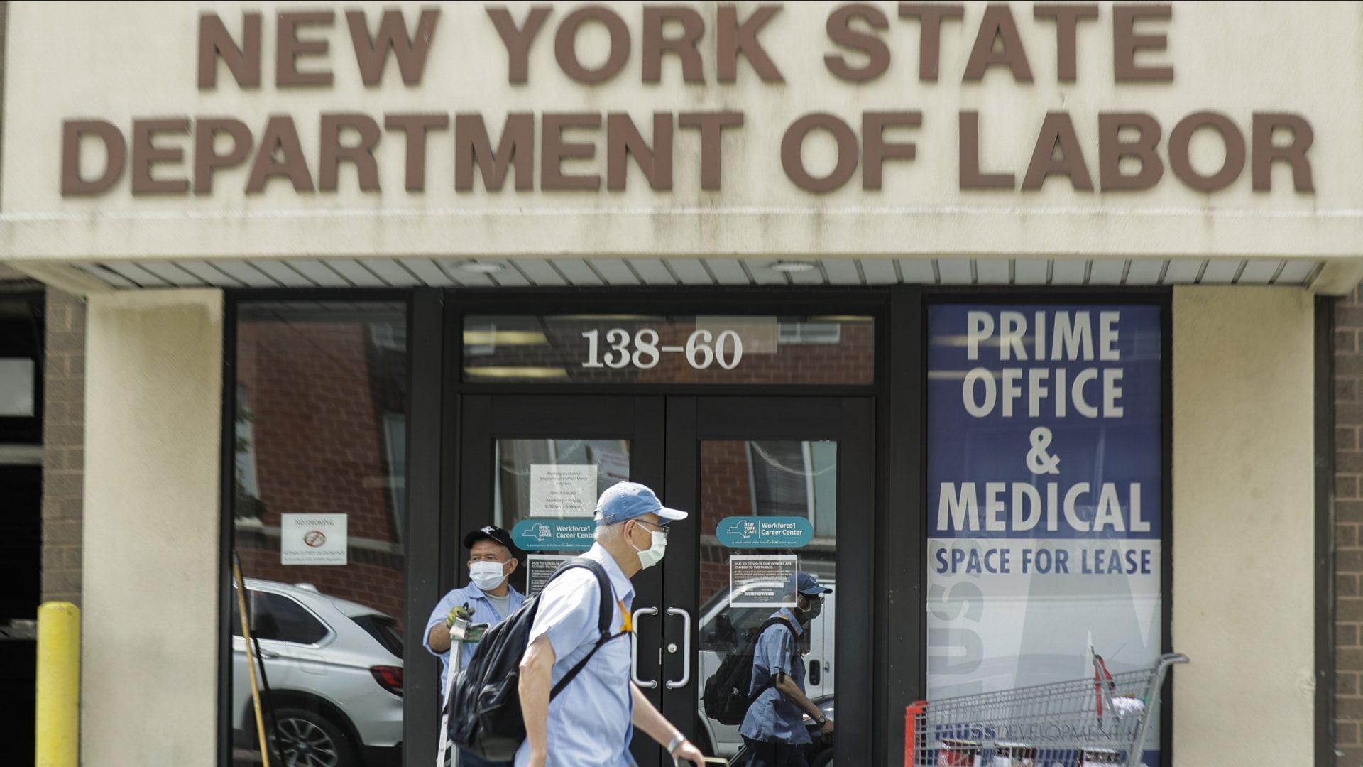 Pedestrians pass a New York State Department of Labor office June 11 in Queens. The Federal Reserve expects the U.S. unemployment rate to still be more than 9% by the end of 2020.