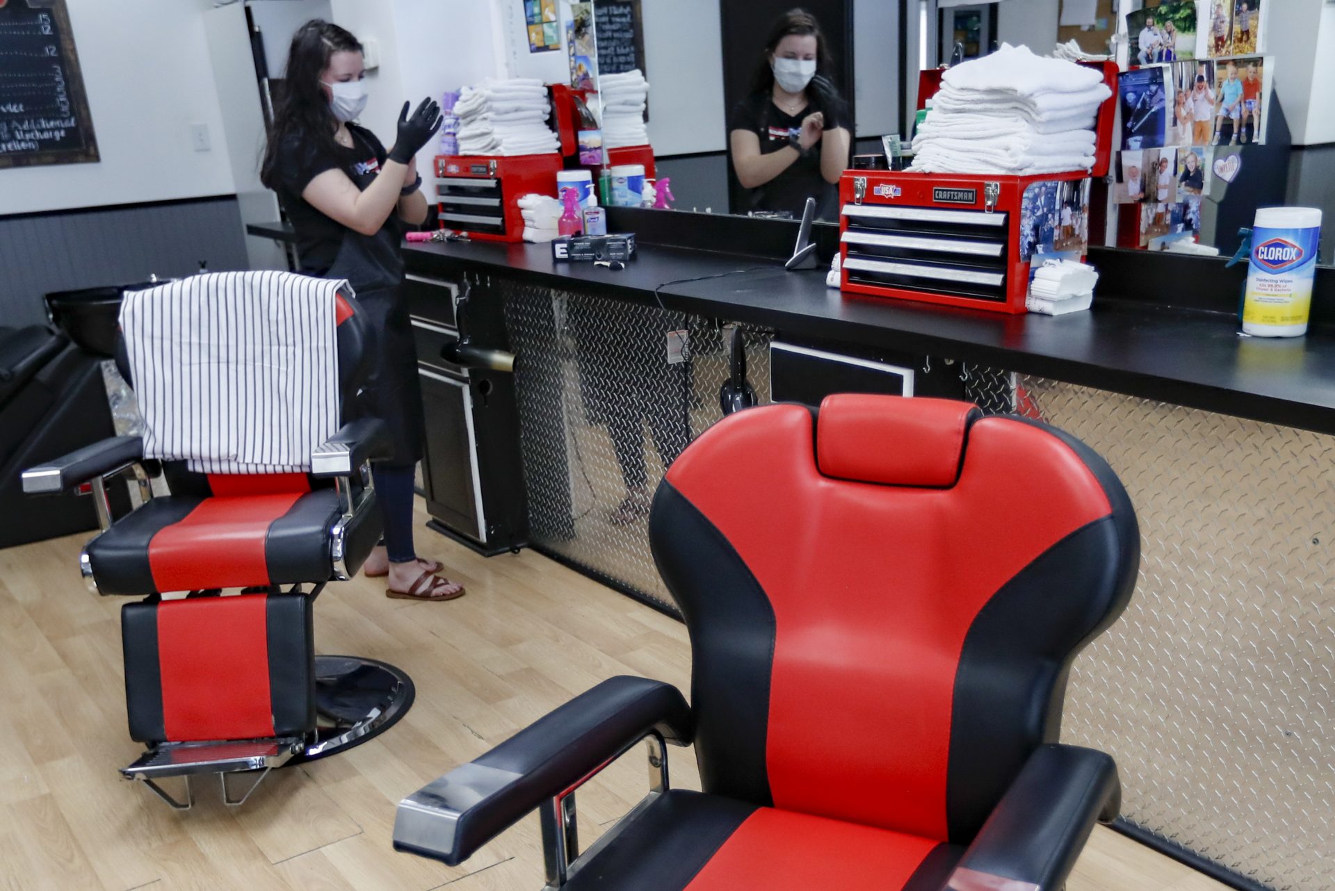 Stylist Kayla Addink arranges items in her workspace Thursday, June 4, 2020, as she prepares for her first day back on the job at the West View Barber Shop when most of southwest Pennsylvania loosens COVID-19 restrictions on Friday in West View, Pa