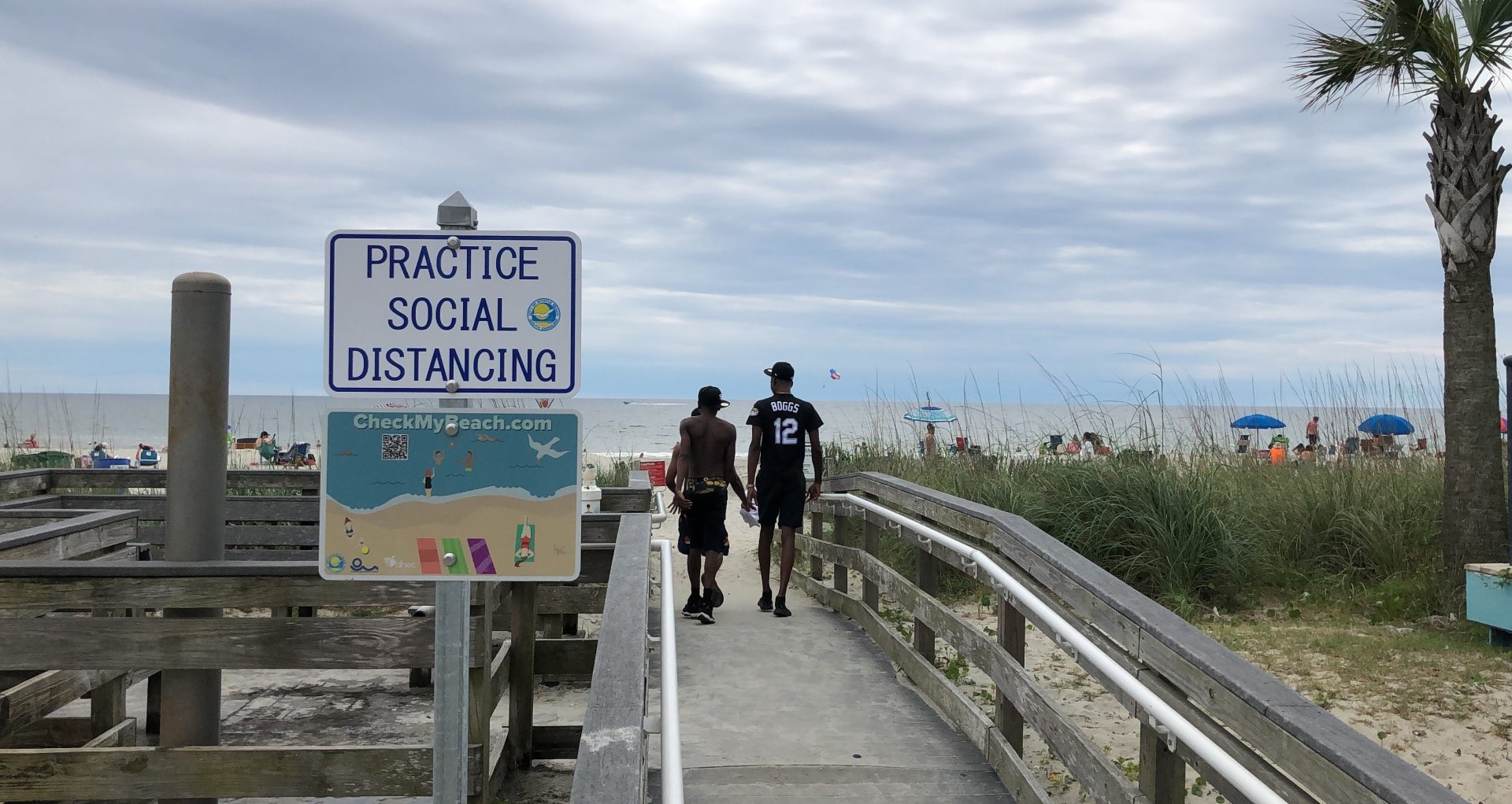 A sign in Myrtle Beach, S.C., Thursday, June 18, 2020, asks people to maintain social distancing on the beach. People are flocking to South Carolina's beaches for vacation after being cooped up by COVID-19 for months. But the virus is taking no vacation as the state has rocketed into the top five in the country in cases divided by population.