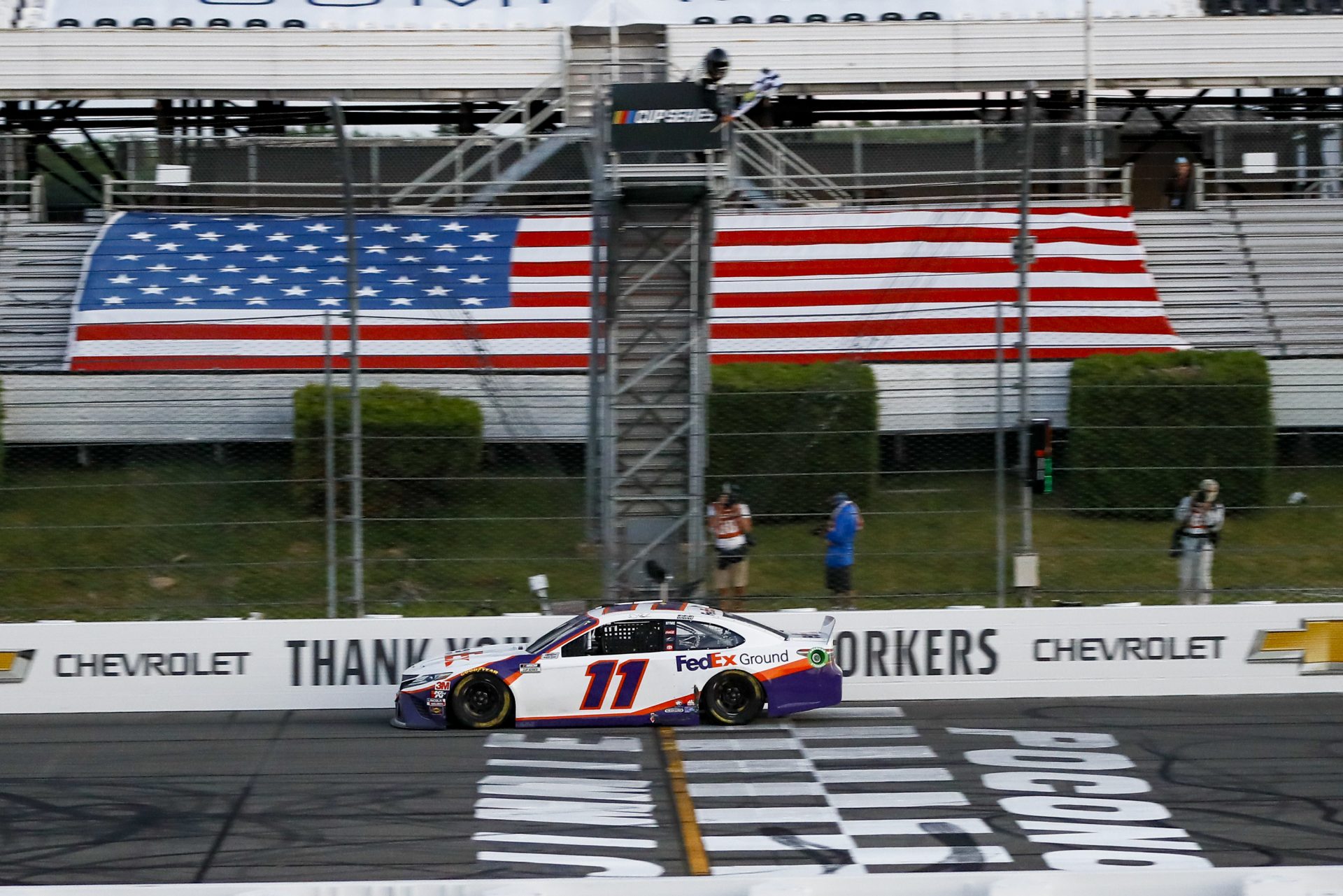 Denny Hamlin gets the checkered flag as he crosses the finish line to win the NASCAR Cup Series auto race at Pocono Raceway, Sunday, June 28, 2020, in Long Pond