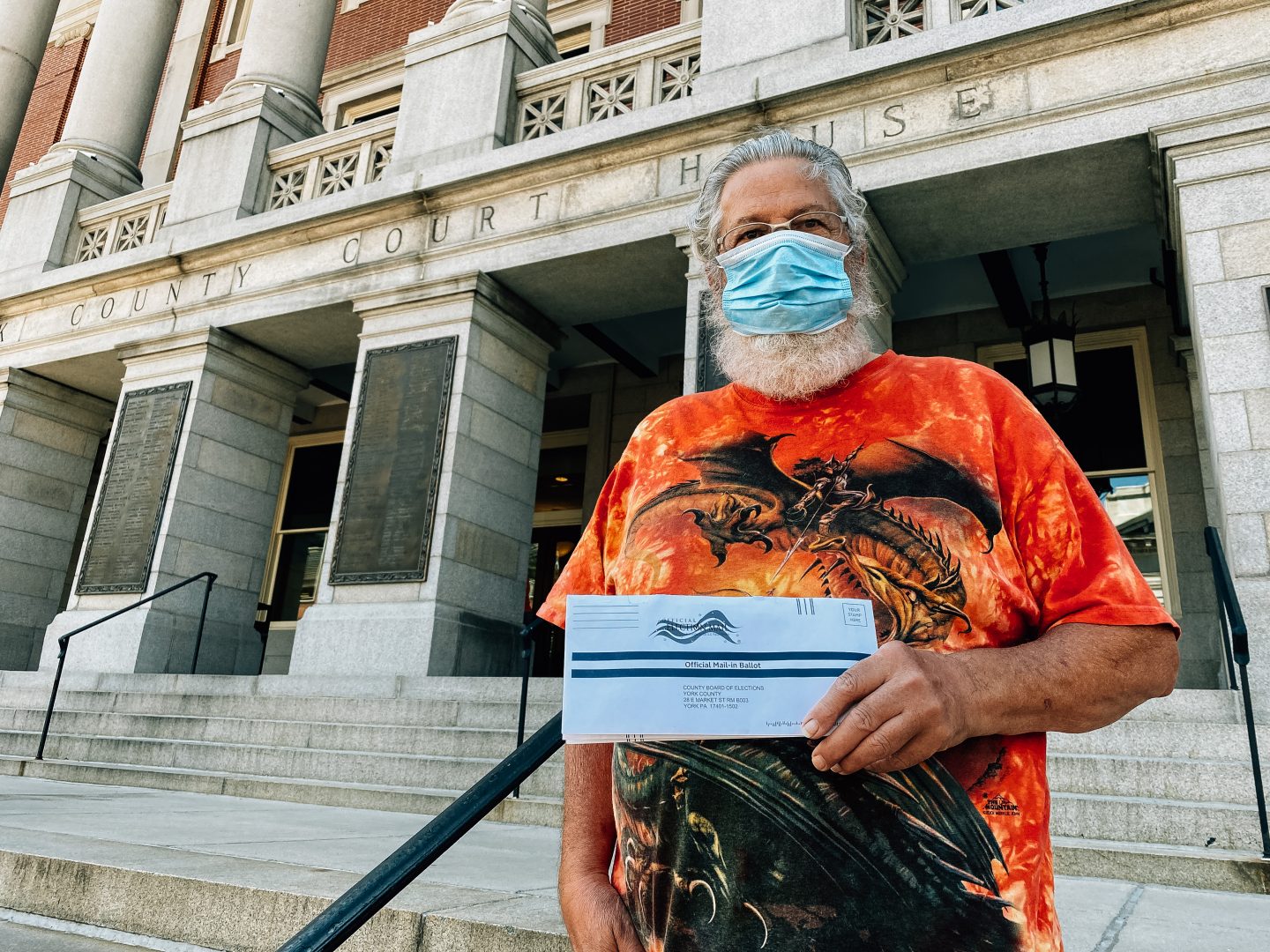 A voter stops for a photo before delivering his ballot to a drop box at the York County Court House on June 1, 2020.
