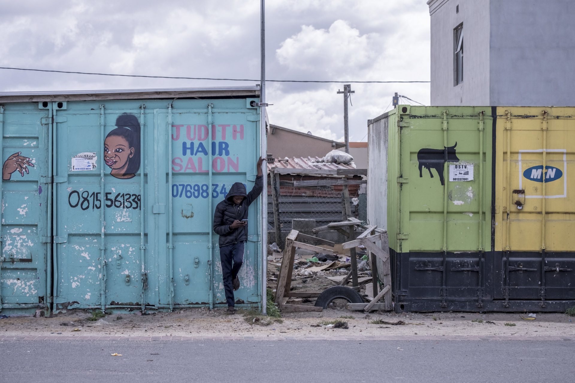 A boy checks his phone outside a shuttered hair salon in the township of Khayelitsha.