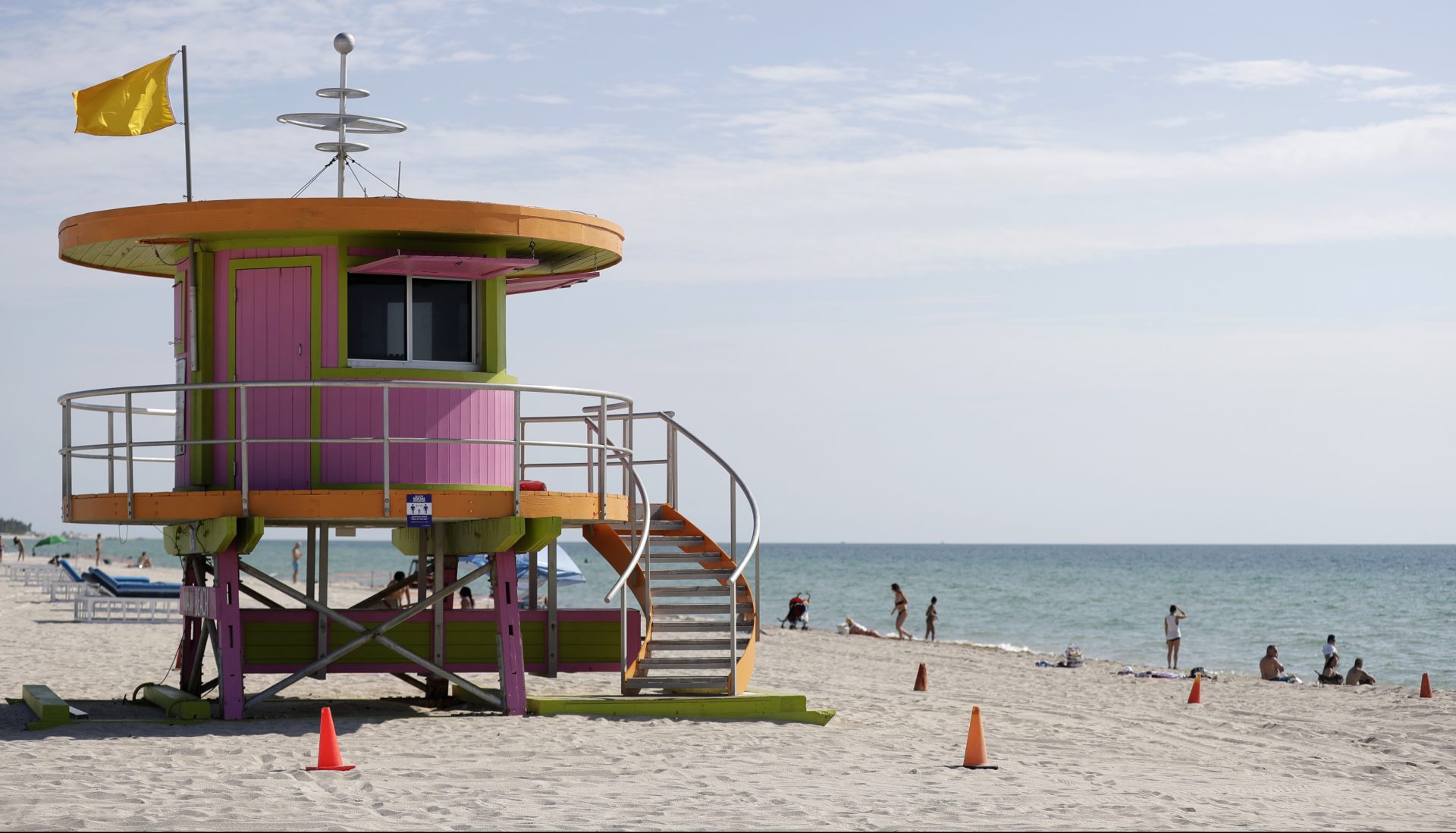 Beachgoers enjoy a day on the sand near a lifeguard stand, Wednesday, June 10, 2020, on Miami Beach, Florida's famed South Beach. Beaches in Miami-Dade County opened with restrictions Wednesday after having been closed for 12 weeks due to the COVID-19 outbreak.