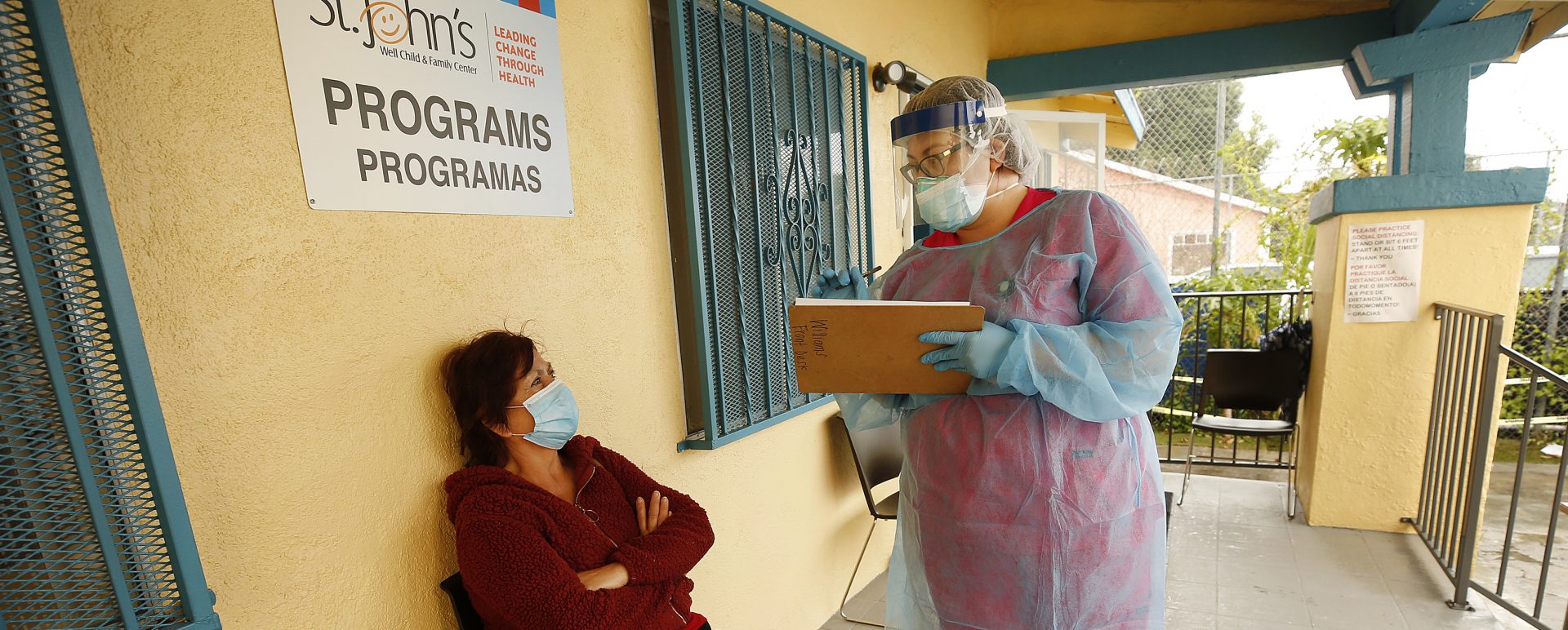 Maria Banderas, left, answers questions from medical assistant Dolores Becerra on May 18 before getting a coronavirus test at St. Johns Well Child and Family Center in South Los Angeles, one of the LA neighborhoods hit hard by COVID-19.