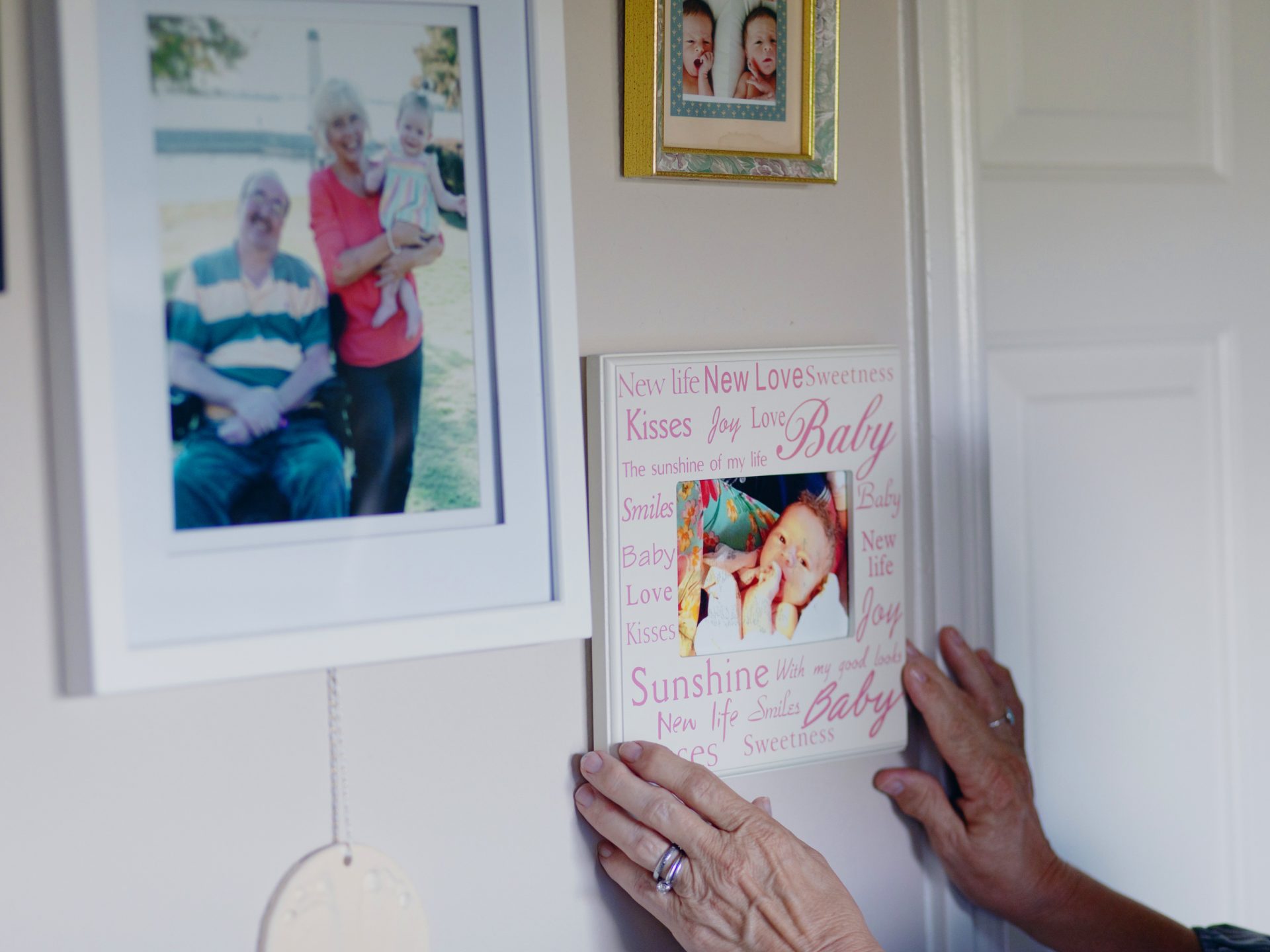 Luann adjusts a family photo at wall in her home. Before the coronavirus outbreak, she would take Jeff to church on Sunday and to the movies. They'd go out for fast food. But she says since the lock down, his anxiety has increased.
