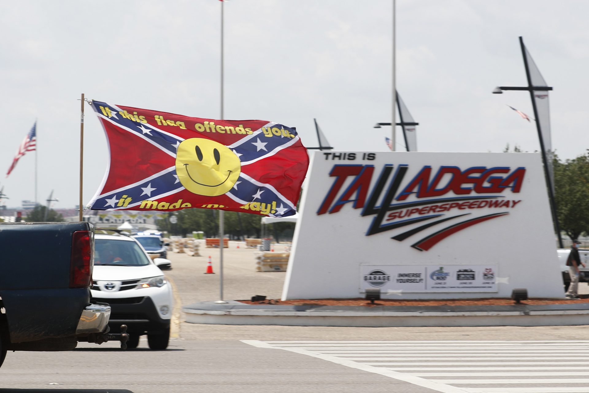 Race fans fly Confederate battle flags and United States flags as they drive by the entrance to Talladega Superspeedway prior to a NASCAR Cup Series auto race in Talladega Ala., Sunday, June 21, 2020.