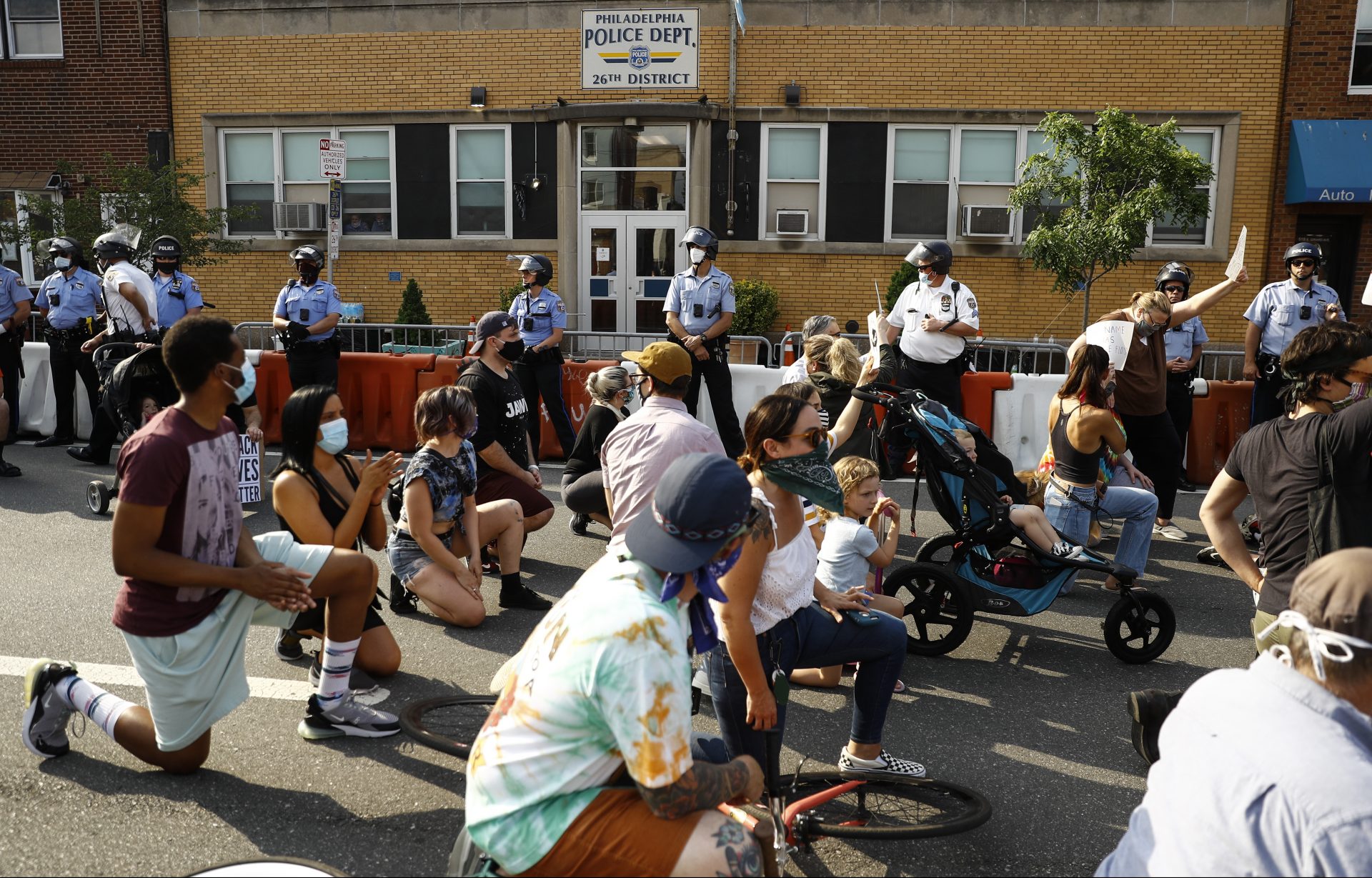 Protesters kneel Wednesday, June 3, 2020, outside the 26th District Police station in the Fishtown neighborhood of Philadelphia, demonstrating against racism and over the death of George Floyd, a black man who died after being restrained by Minneapolis police officers on May 25.