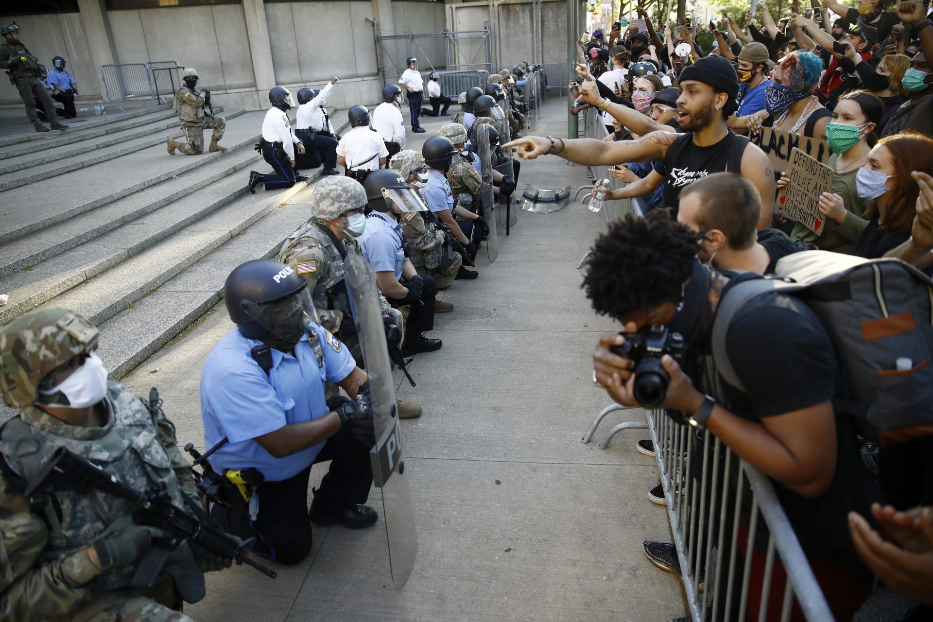 Philadelphia police and National Guard take a knee at the suggestion of Philadelphia Police Deputy Commissioner Melvin Singleton, unseen, outside Philadelphia Police headquarters in Philadelphia, Monday, June 1, 2020 during a march calling for justice over the death of George Floyd, Floyd died after being restrained by Minneapolis police officers on May 25.